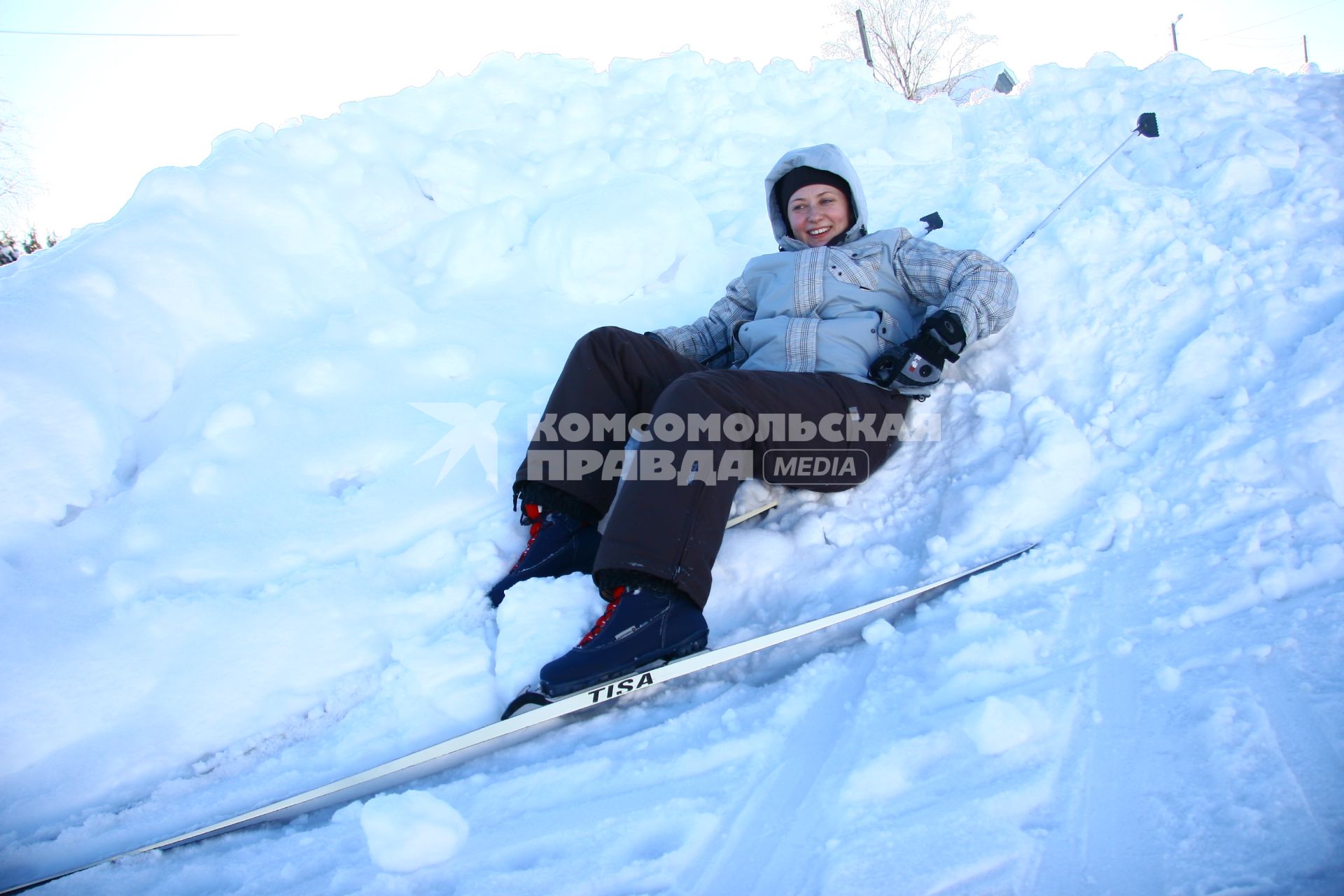 Девушка занимается лыжным спортом в деревне под Нижним Новгородом. Лежит с сугробе. 7 января 2011 года.