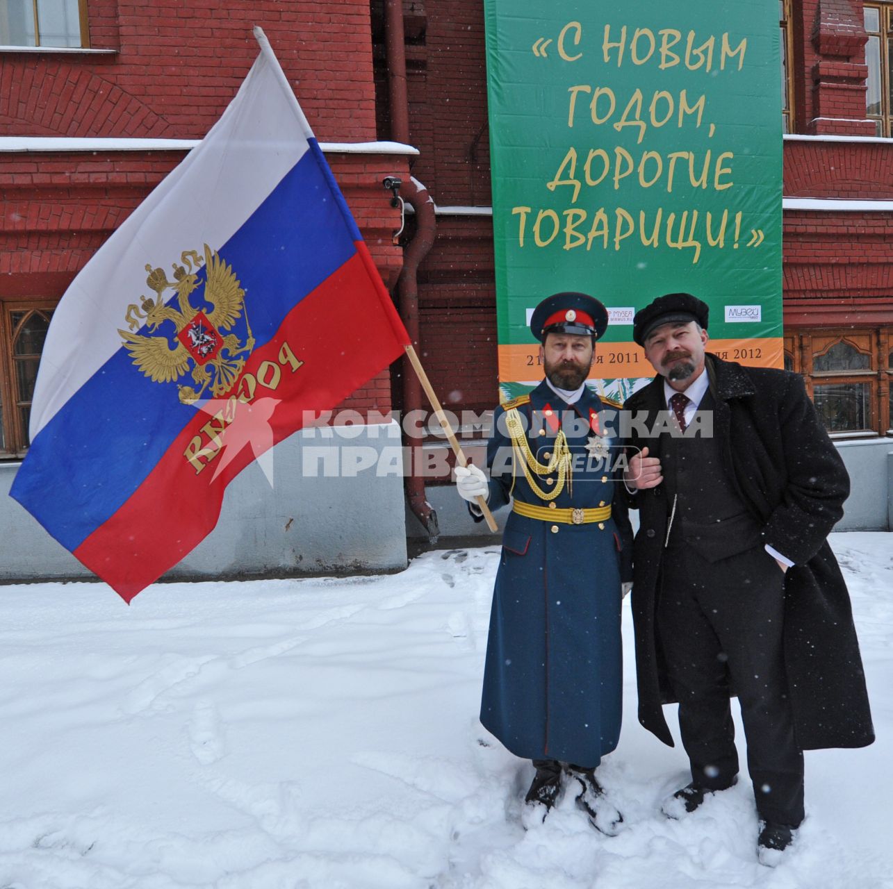 Жанровая фотография. Мужчины в образе В.И.Ленина и царя Николая второго стоят на фоне плаката С НОВЫМ ГОДОМ, ДОРОГИЕ ТОВАРИЩИ!. Москва. 21 декабря  2011 года.