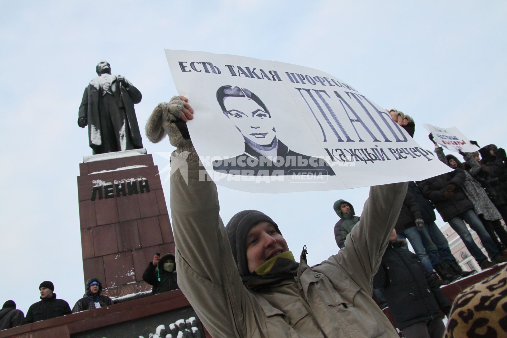 Акция протеста против фальсификации выборов в государственную думу. Несанкционированный митинг на площади Свободы. Казань. На снимке: Митингующий с плакатом, на плакате надпись: ЕСТЬ ТАКАЯ ПРОФЕССИЯ ЛГАТЬ КАЖДЫЙ ВЕЧЕР на фоне памятника Ленину. 10 декабря 2011 года.