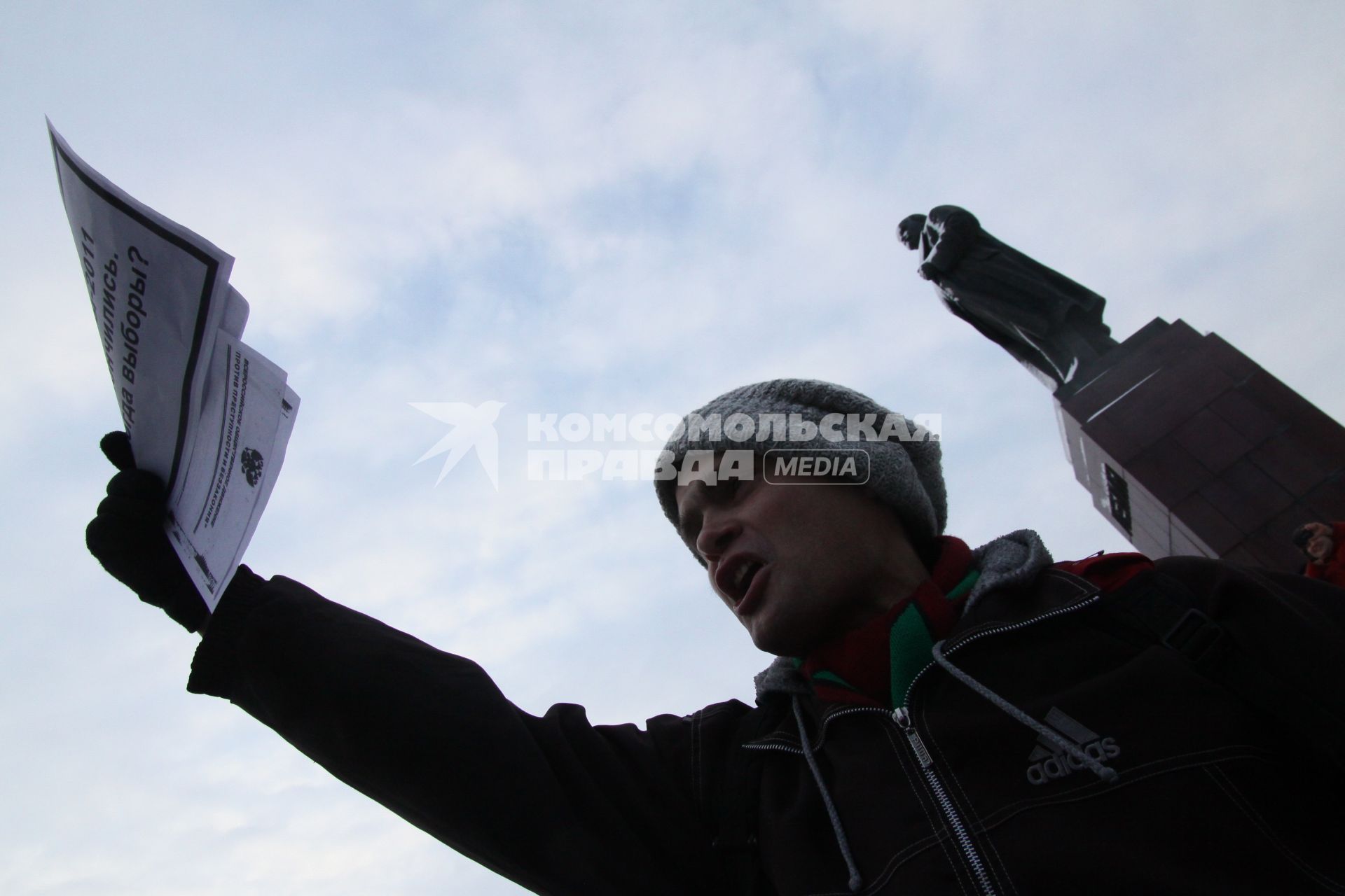 Акция протеста против фальсификации выборов в государственную думу. Несанкционированный митинг на площади Свободы. Казань. На снимке: митингующий с листовками на фоне памятника Ленину. 10 декабря 2011 года.