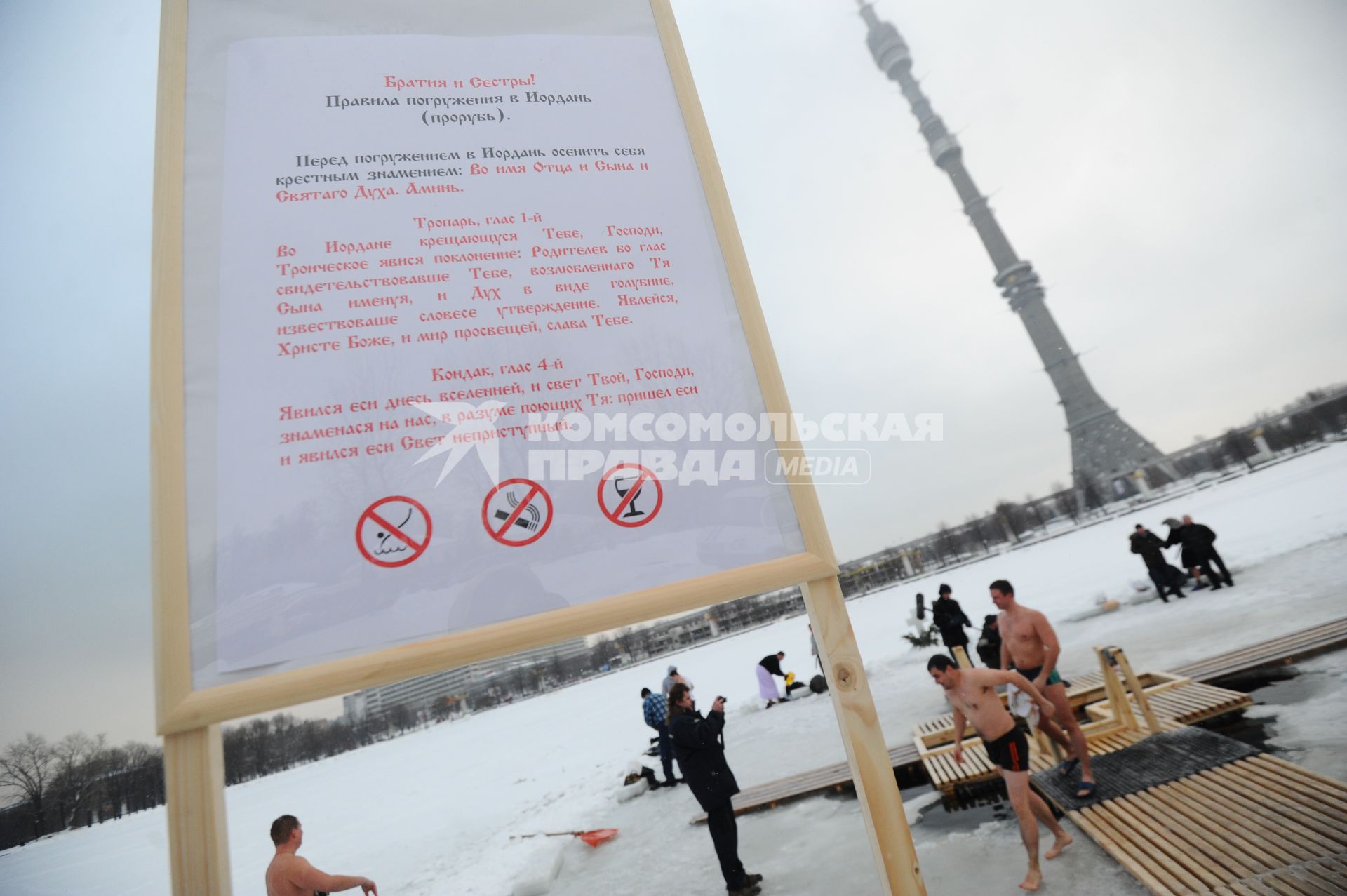 Во время традиционного крещенского купания в Останкинском пруду.  На снимке: правила погружения в Иордань (прорубь).  Москва. 19 января 2012 года.