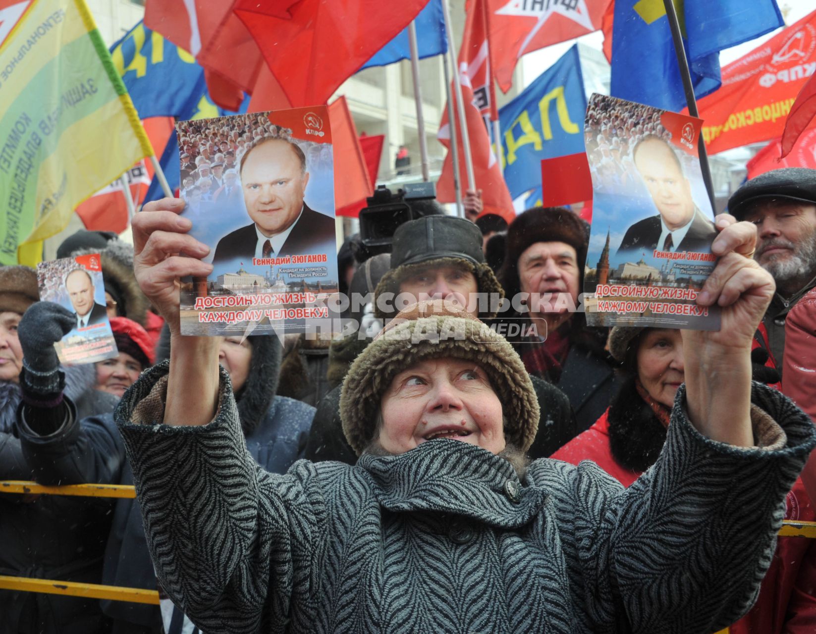 Во время митинга КПРФ  ЗА ДОСТОЙНУЮ ЖИЗНЬ И ЧЕСТНЫЕ ВЫБОРЫ  на Манежной площади. На снимке: женщина держит листовки с портретом Зюганова и надписью ДОСТОЙНУЮ ЖИЗНЬ-КАЖДОМУ ЧЕЛОВЕКУ!. 21 января 2012 года.