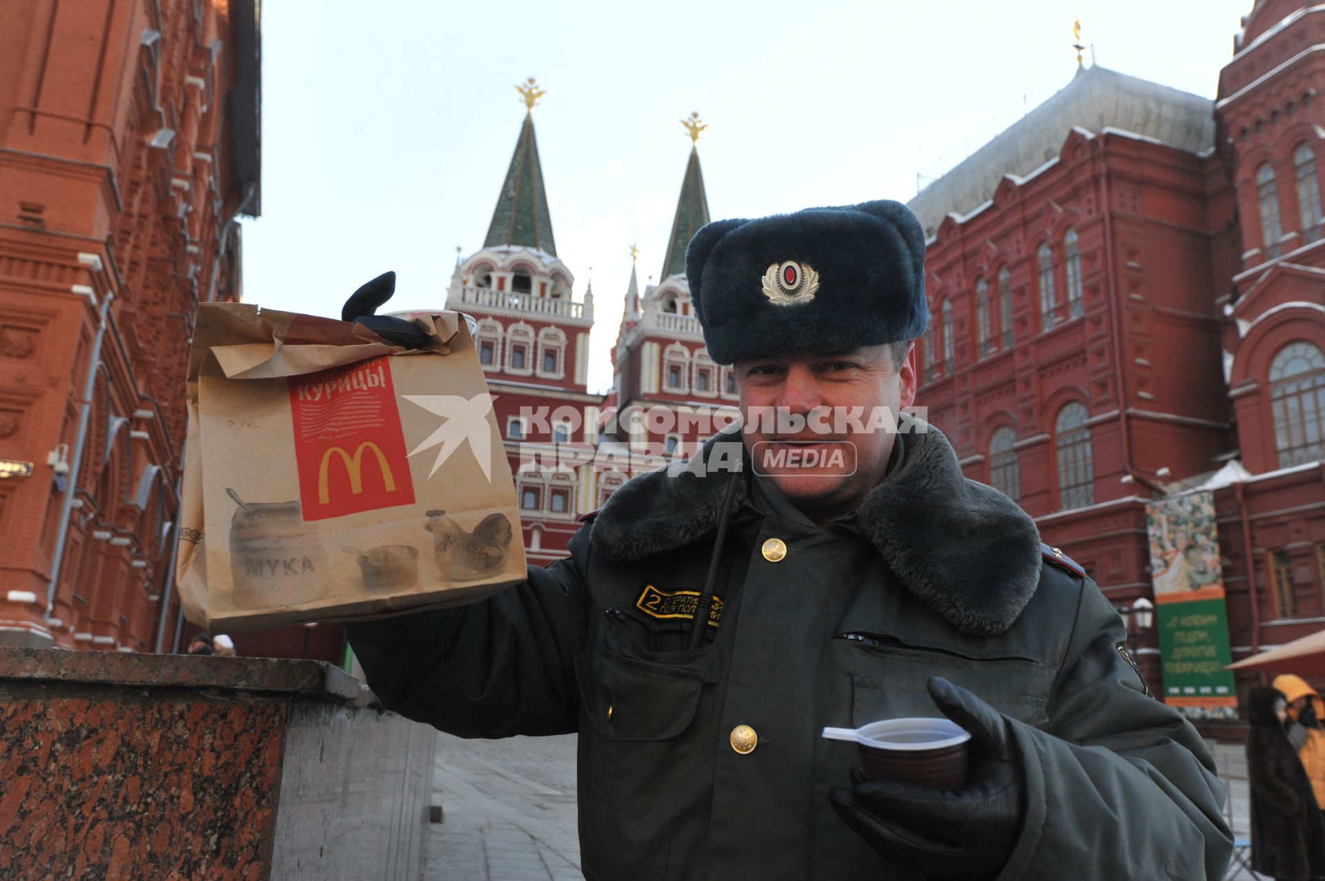 Зима. Полицейский держит в руках горячий чай и фирменный пакет Макдональдс. 24 января 2012 года.