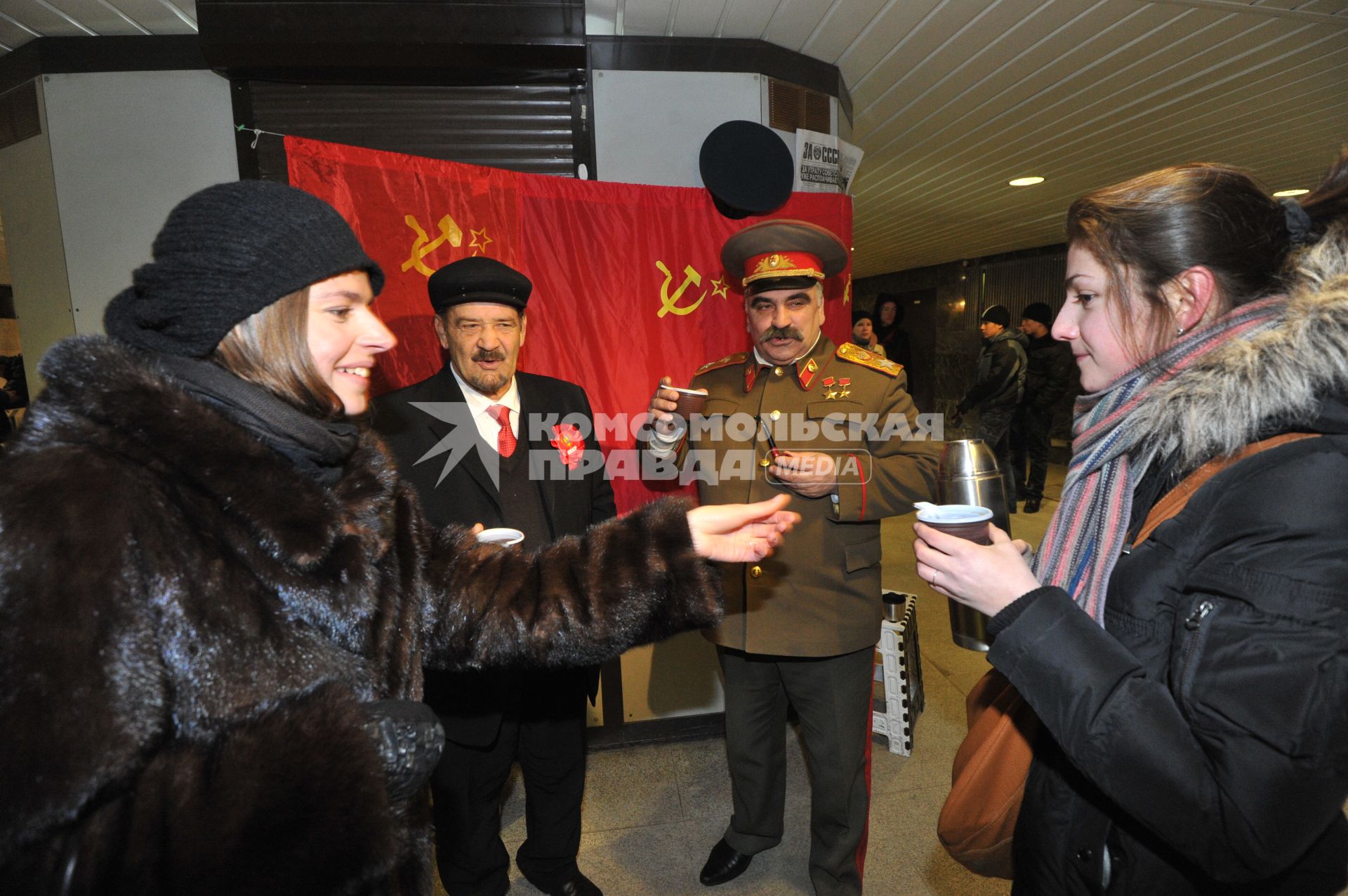 Подземный переход метро. Девушки угощают мужчин в образе В.И.Ленина и И.В.Сталина горячим чаем из термоса. 24 января 2012 года.