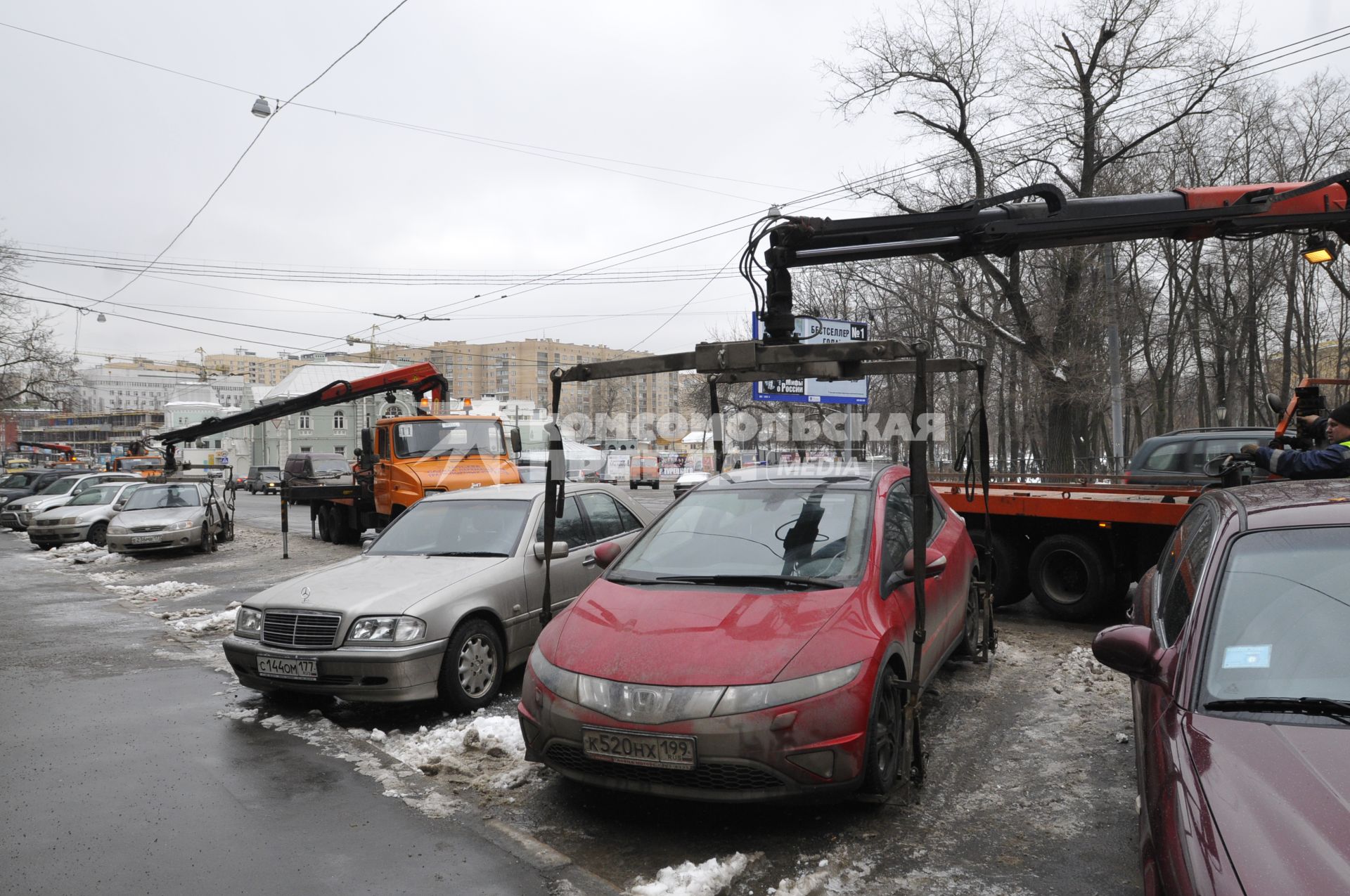 Сотрудники коммунальных служб города убирают на эвакуатор автомобиль \"Хонда\" (Honda) . Москва. 29 января 2009 года.
