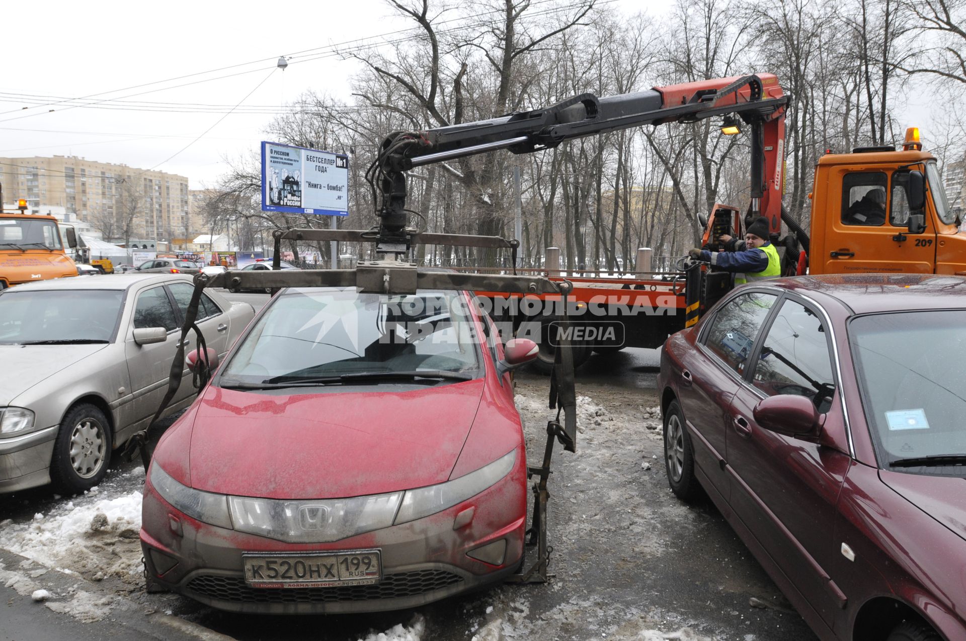 Сотрудники коммунальных служб города убирают на эвакуатор автомобиль \"Хонда\" (Honda) . Москва. 29 января 2009 года.