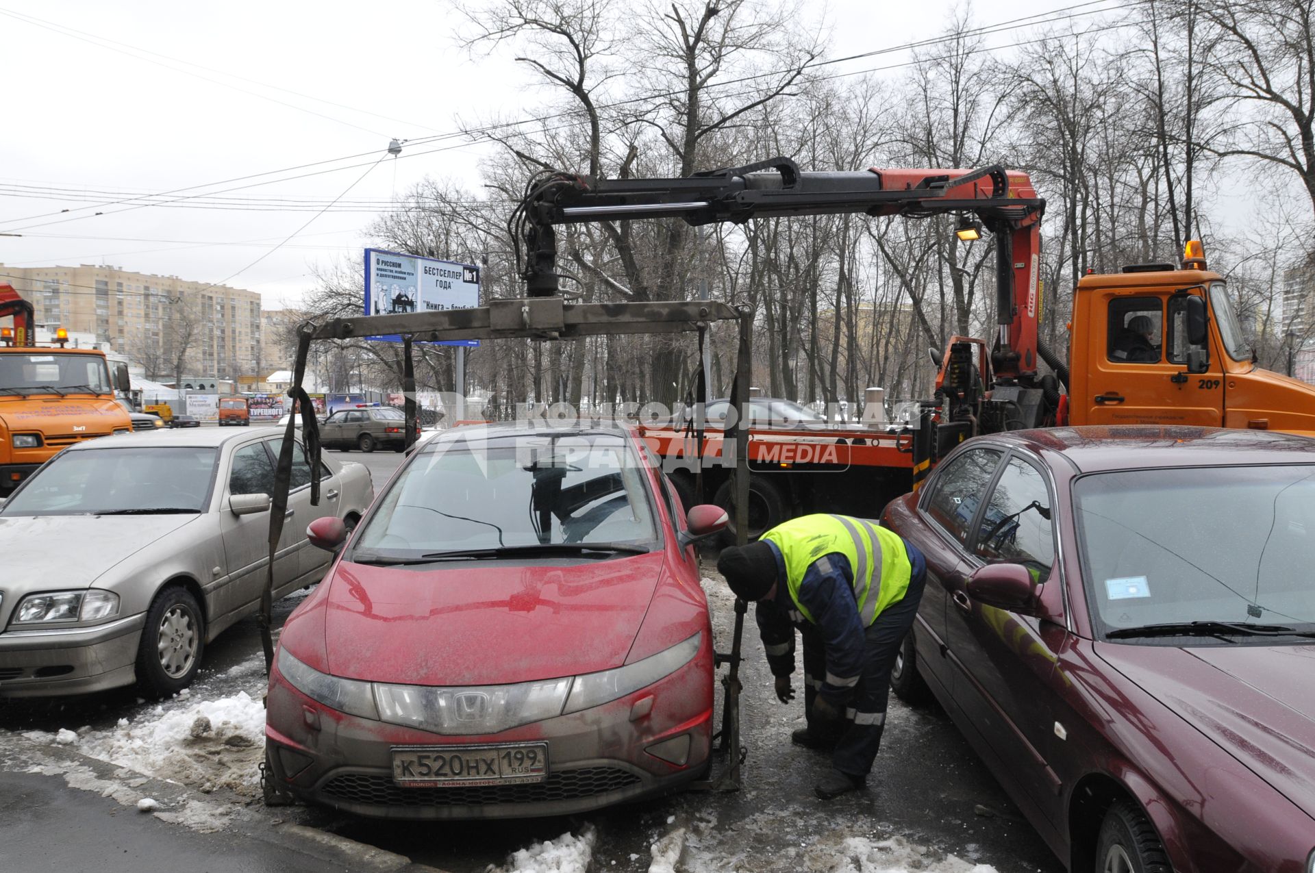 Сотрудники коммунальных служб города убирают на эвакуатор автомобиль \"Хонда\" (Honda) . Москва. 29 января 2009 года.