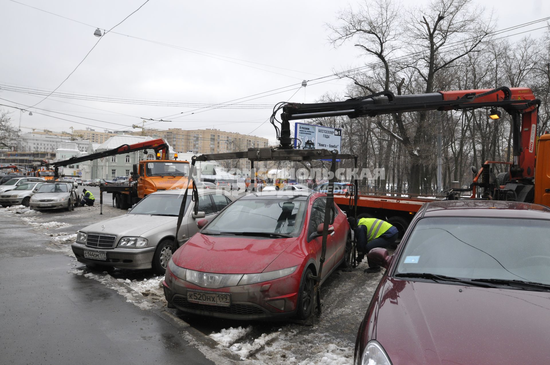 Сотрудники коммунальных служб города убирают на эвакуатор автомобиль \"Хонда\" (Honda) . Москва. 29 января 2009 года.