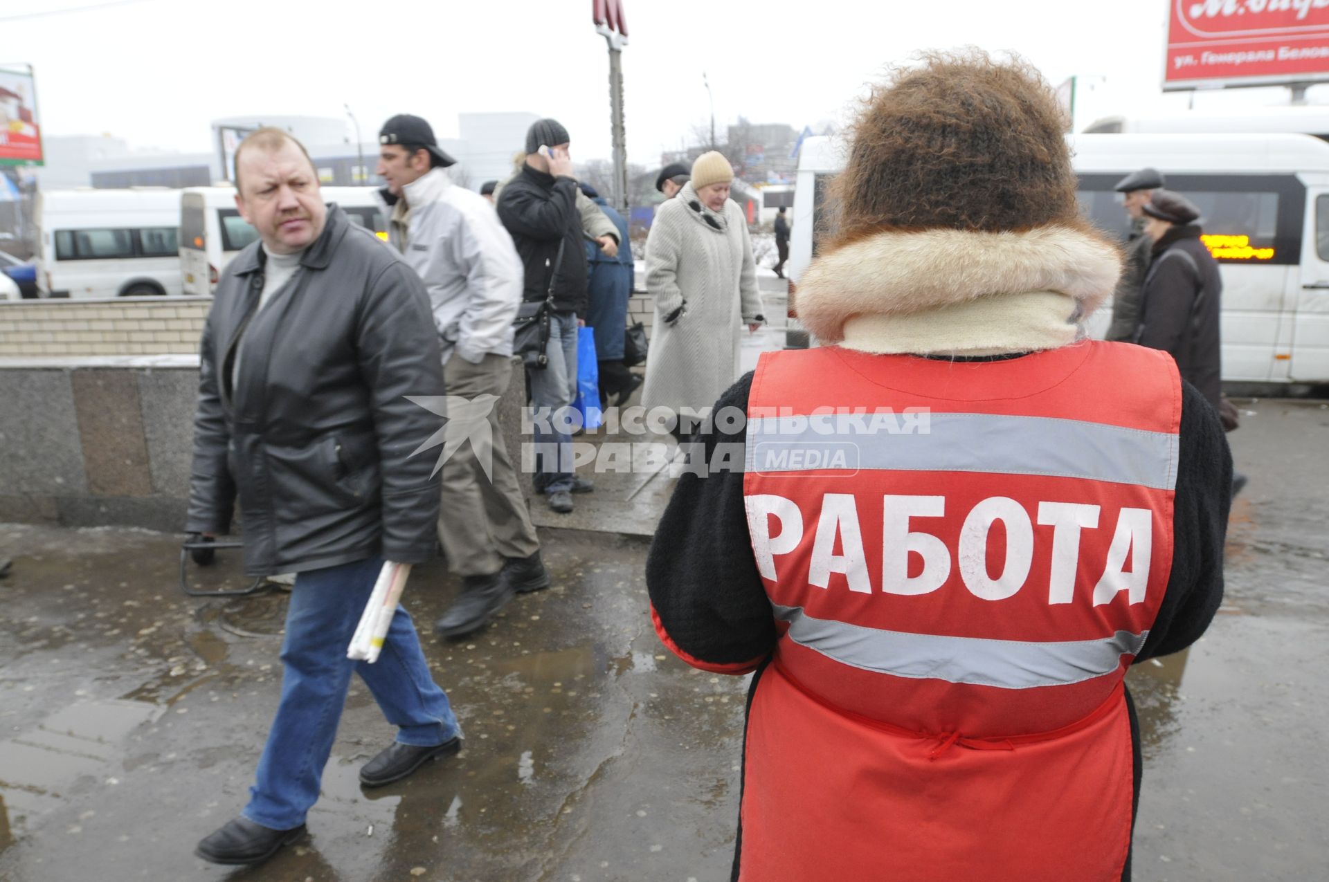 Женщина на улице распространяет бесплатную газету по трудоустройству \"Работай рядом с домом\".  Москва. 10 февраля 2009 года.