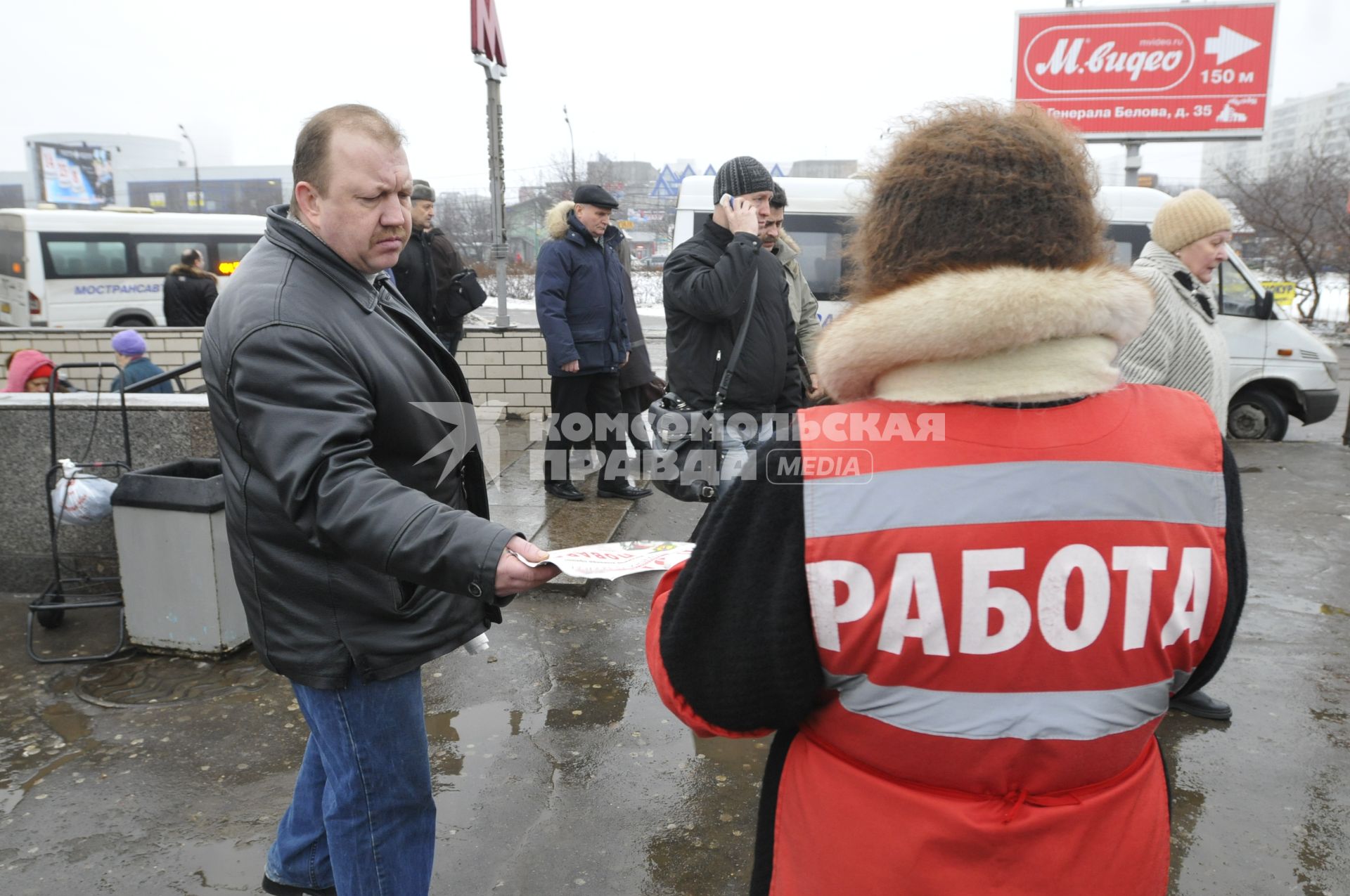 Женщина на улице распространяет бесплатную газету по трудоустройству \"Работай рядом с домом\".  Москва. 10 февраля 2009 года.