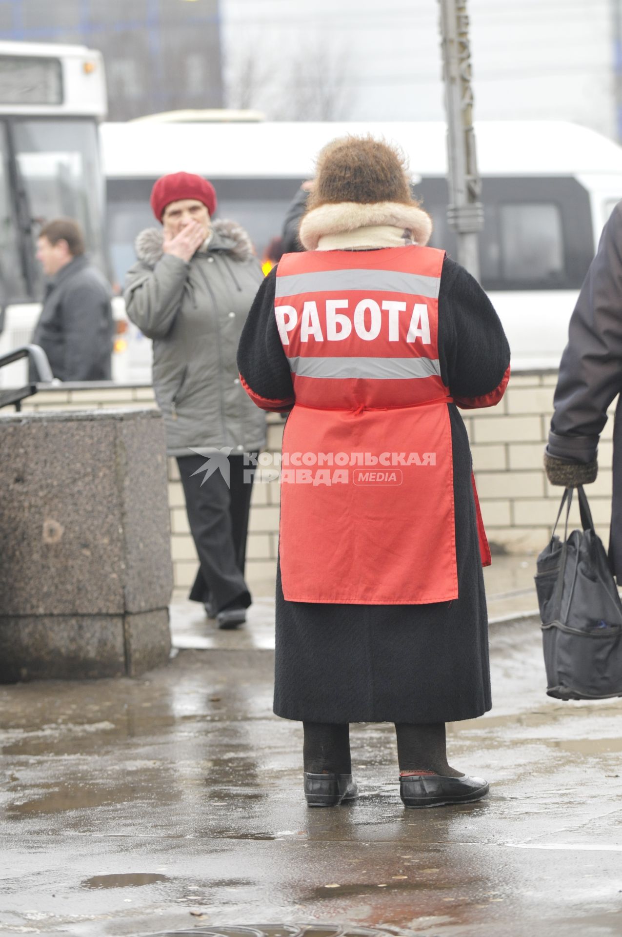 Женщина на улице распространяет бесплатную газету по трудоустройству \"Работай рядом с домом\".  Москва. 10 февраля 2009 года.