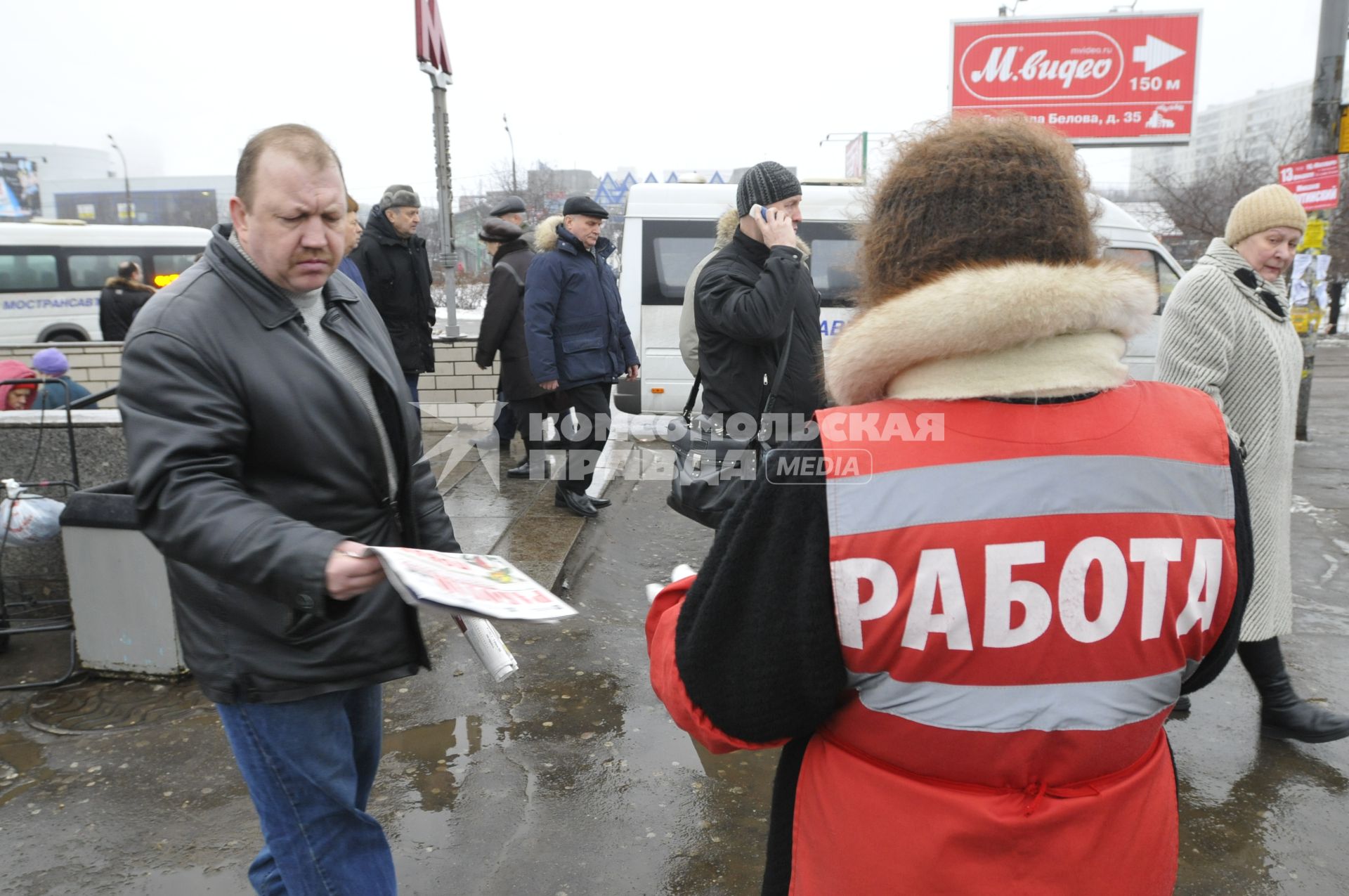 Женщина на улице распространяет бесплатную газету по трудоустройству \"Работай рядом с домом\".  Москва. 10 февраля 2009 года.