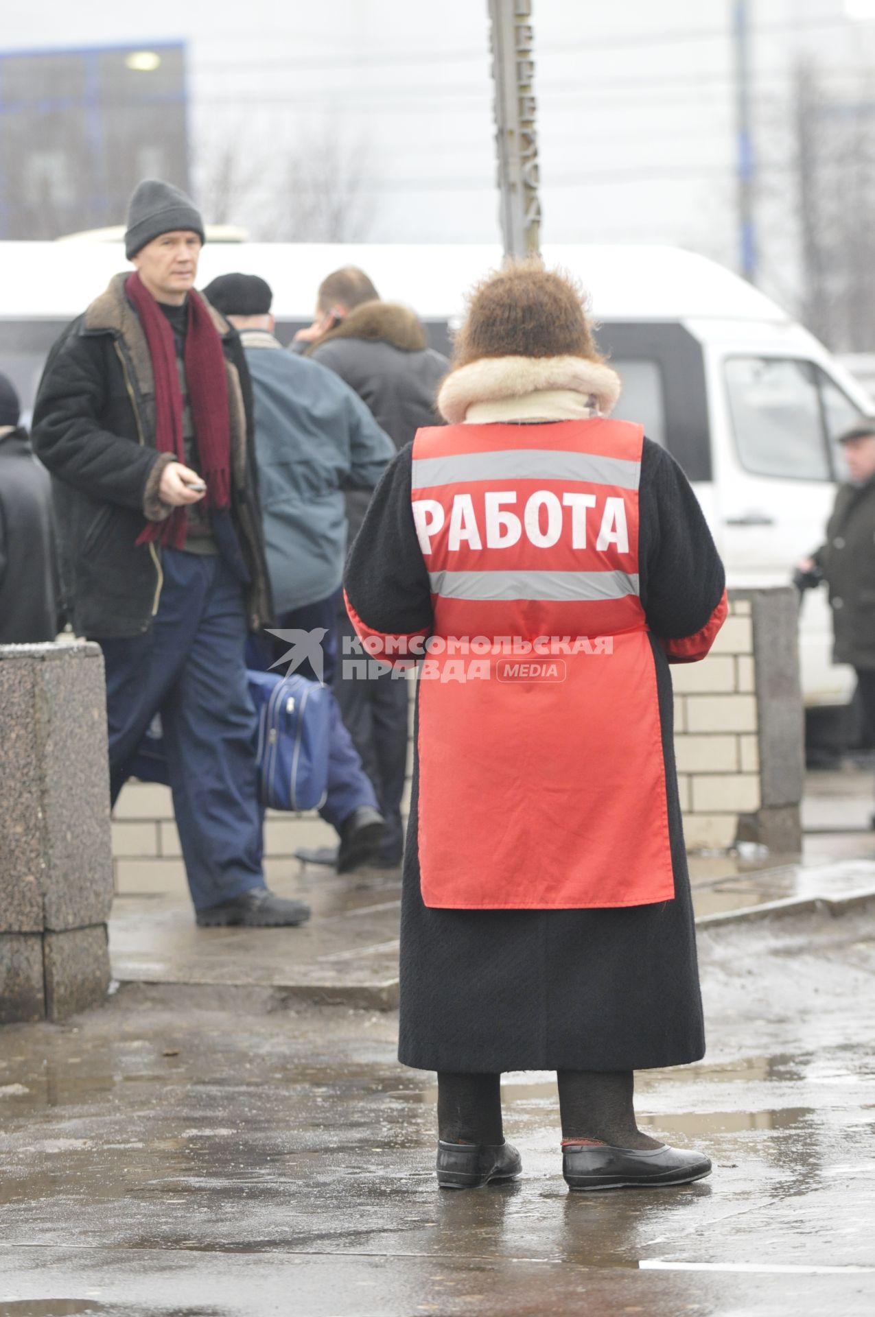 Женщина на улице распространяет бесплатную газету по трудоустройству \"Работай рядом с домом\".  Москва. 10 февраля 2009 года.