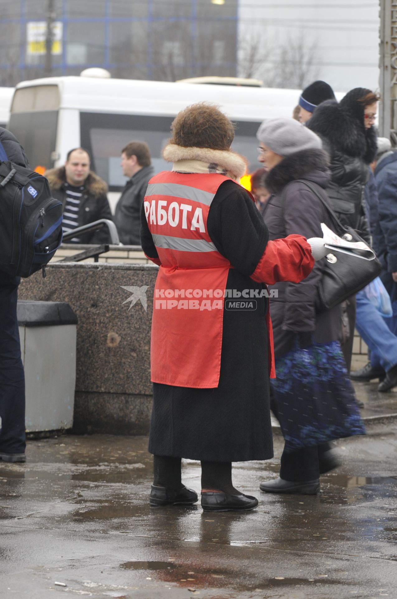 Женщина на улице распространяет бесплатную газету по трудоустройству \"Работай рядом с домом\".  Москва. 10 февраля 2009 года.