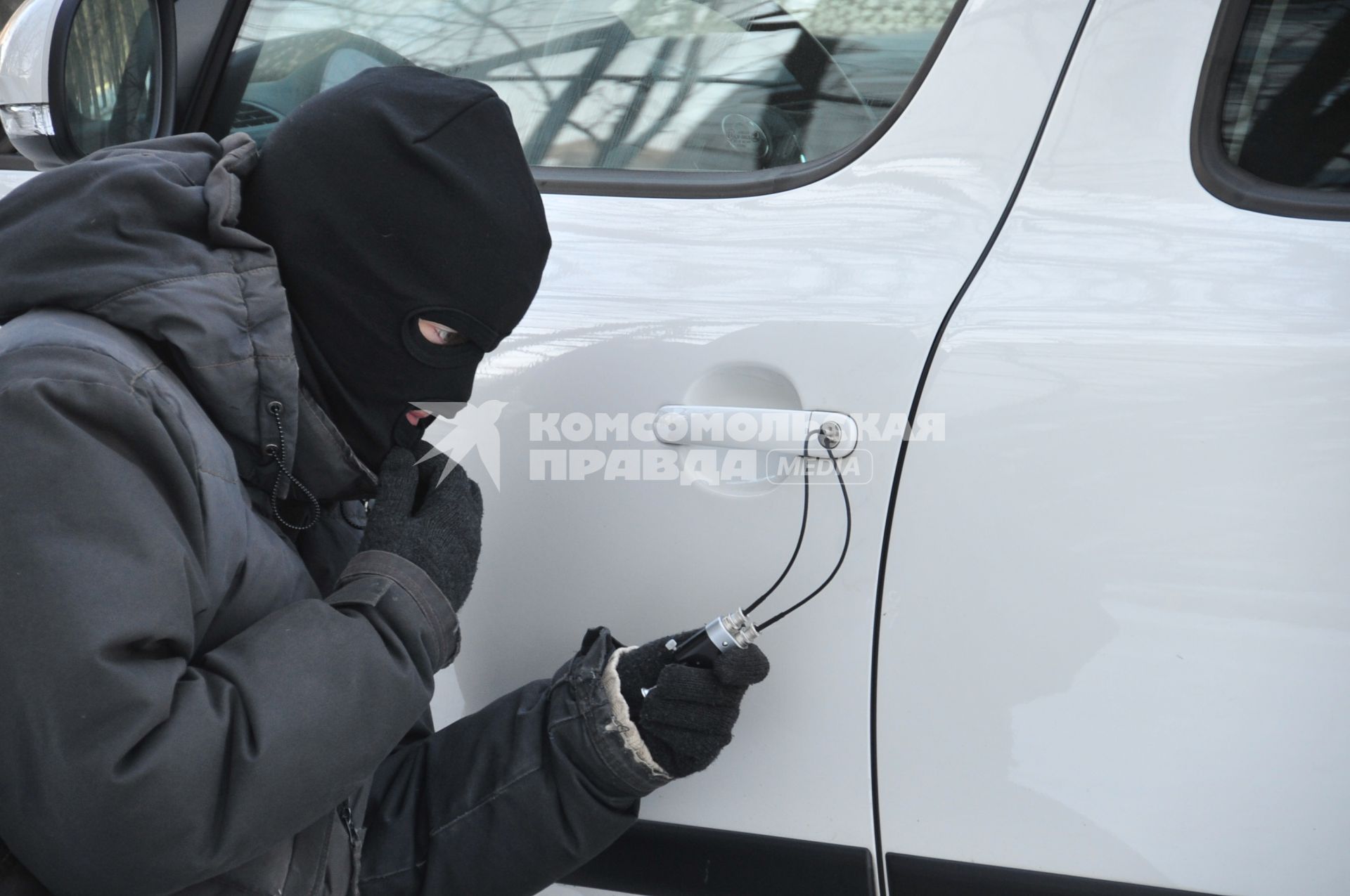 Мужчина в маске пытается открыть дверь автомобиля. Кража автомобиля. Угонщик. Вор. 29 января 2012