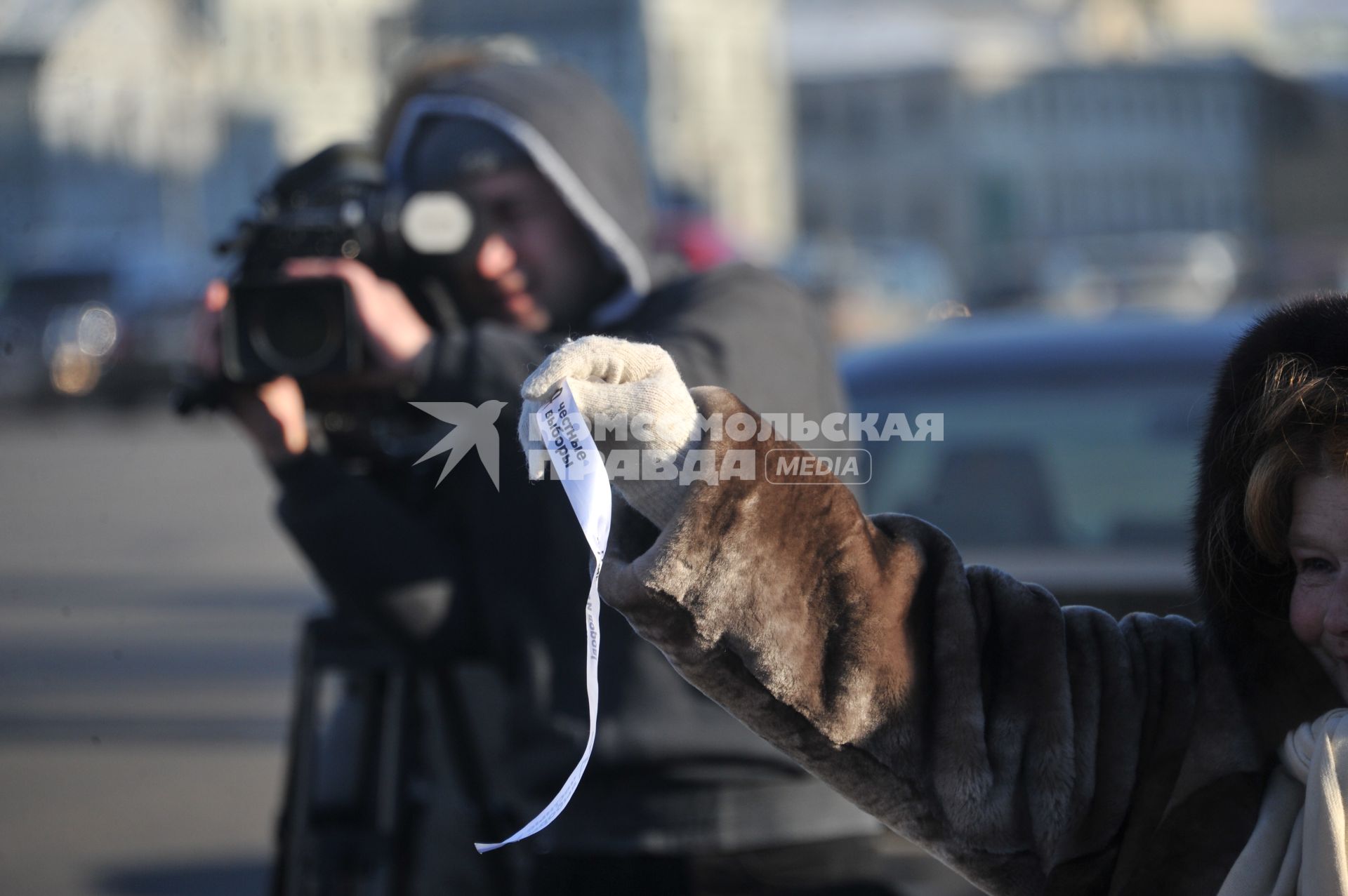 В Москве на Садовом кольце прошел автопробег  ЗА ЧЕСТНЫЕ ВЫБОРЫ. На снимке: телеоператор за работой и женщина с белой ленточкой. 29 января 2012