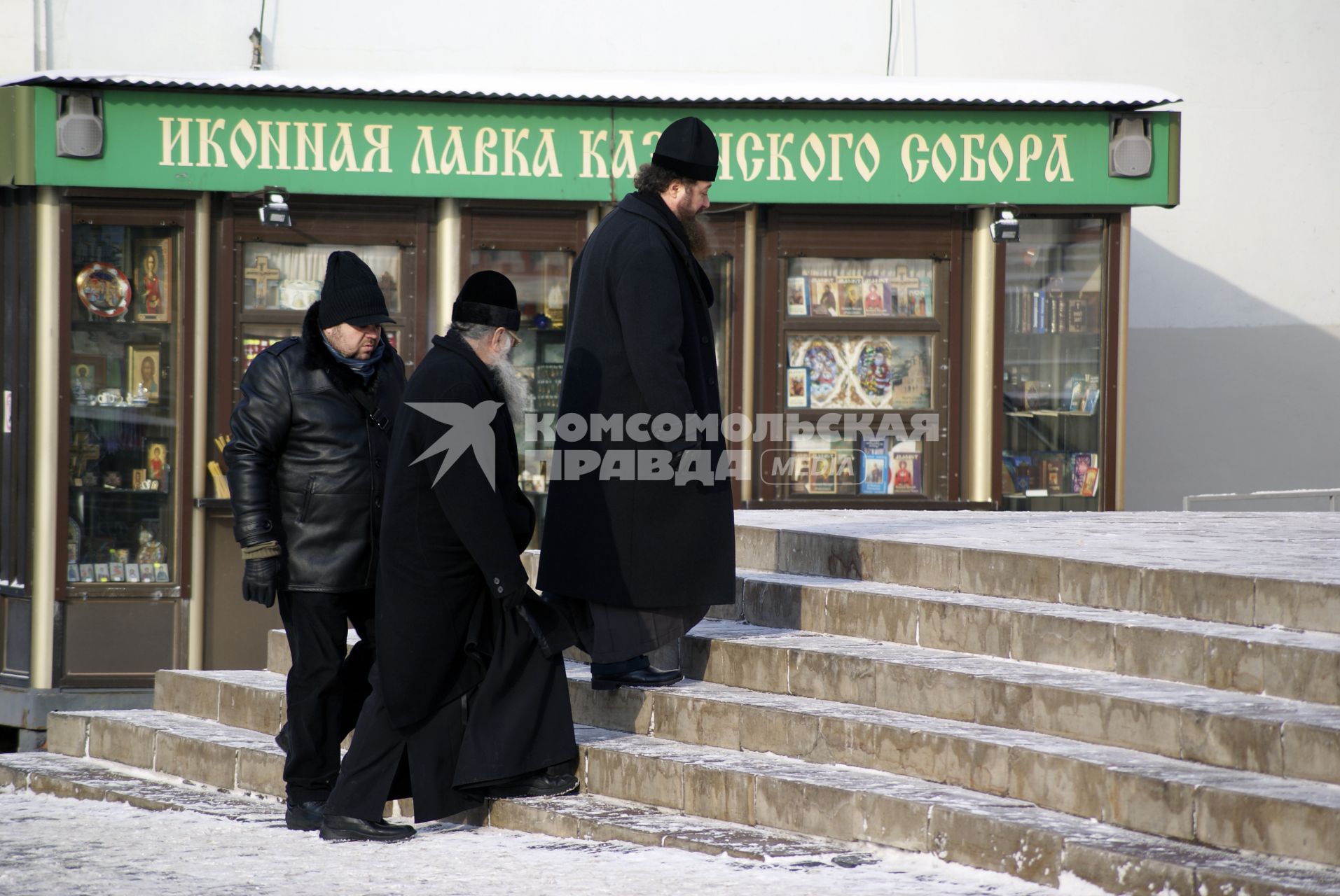 Священнослужители идут общаясь с прихожанином.