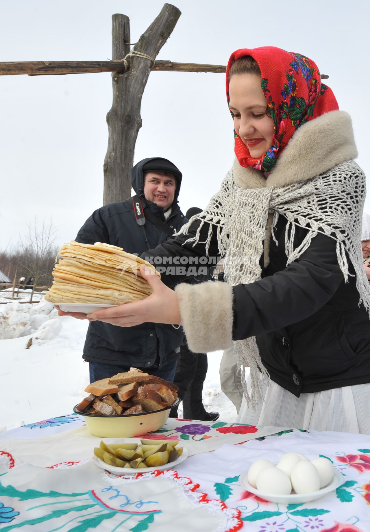 Молодая красивая девушка с блинами ставит тарелку на стол. Деревня Озерцо/Минская область.