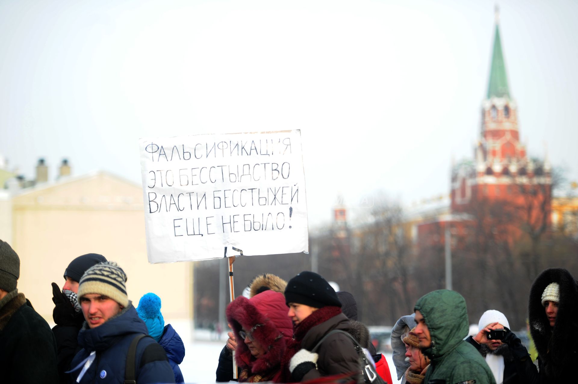 Толпа людей на митинге ЗА ЧЕСТНЫЕ ВЫБОРЫ несет плакат Фальсификация это бесстыдство власти бесстыжей еще не было, Москва, 4 февраля 2012