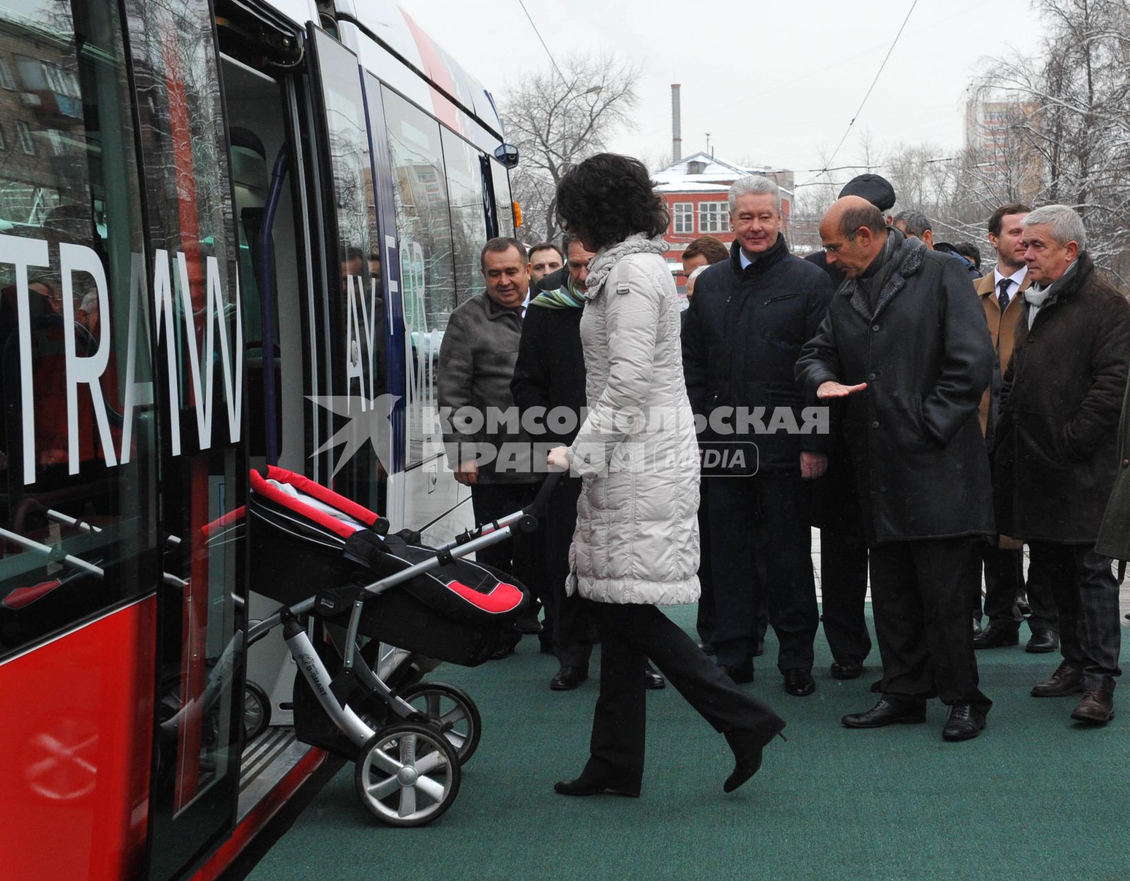 В Москве состоялась презентация трамвая нового поколения, совместная разработка франзузской фирмы `Alstom` и `Трансмашхолдинг`. На снимке: женщина с коляской входит в трамвай, на заднем плане мэр Москвы Сергей Собянин (третий справа на втором плане).