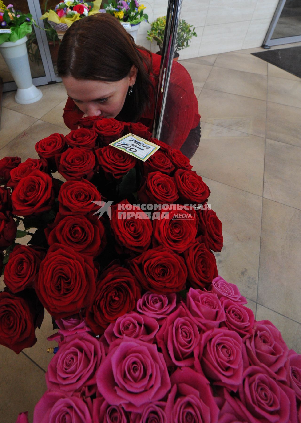 Цветочный магазин. На снимке: женщина и розы.