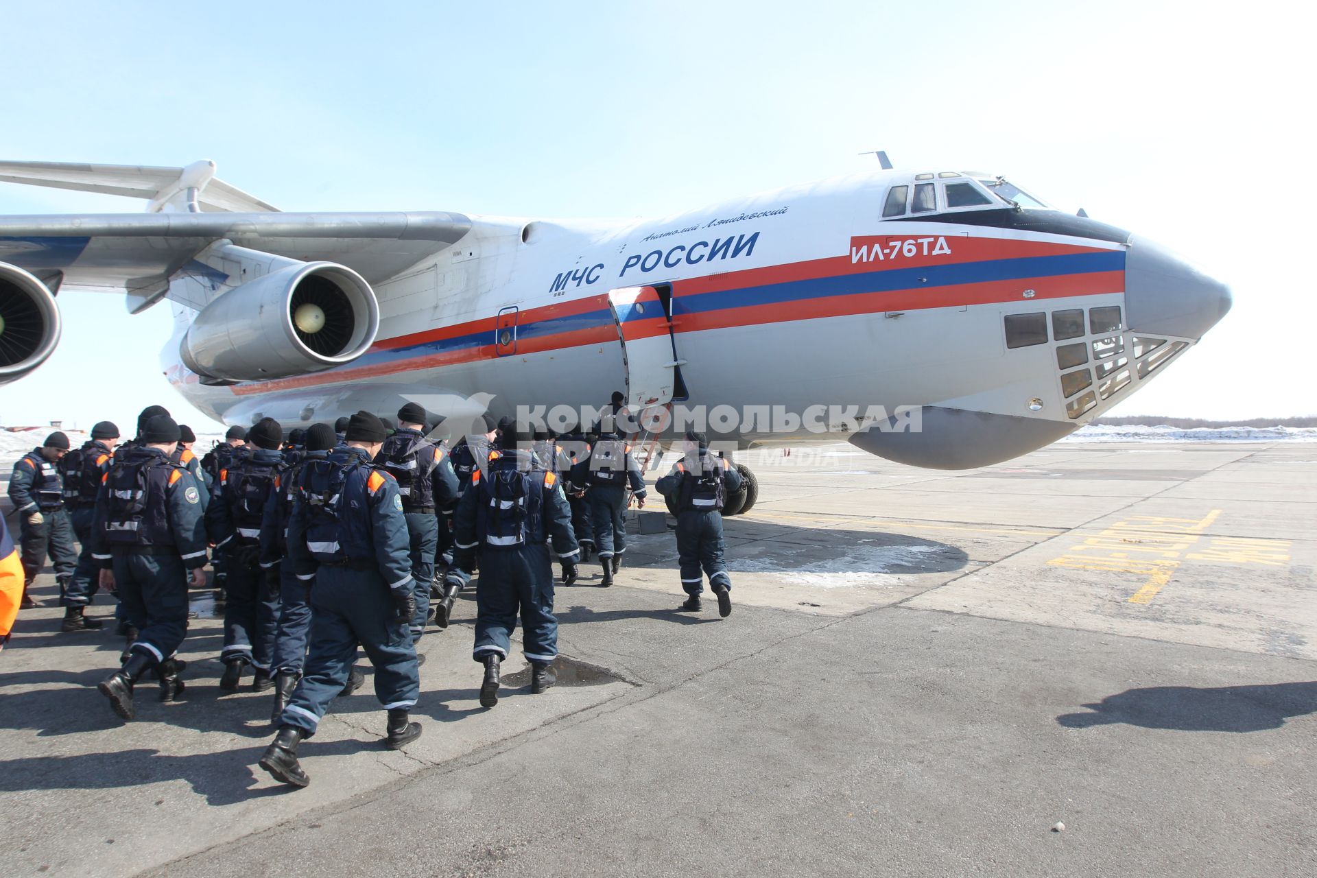 Сотрудники МЧС готовятся к перелету в Японию где произошло сильнейшее землетрясение и цунами. Спасатели заходят в самолет.