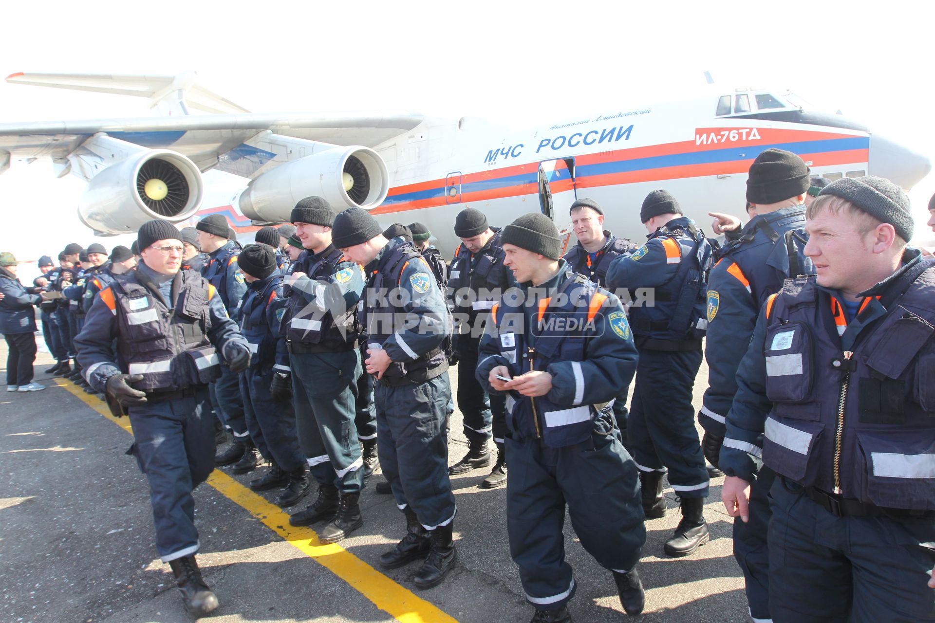 Сотрудники МЧС готовятся к перелету в Японию где произошло сильнейшее землетрясение и цунами. Спасатели стоят около самолета.