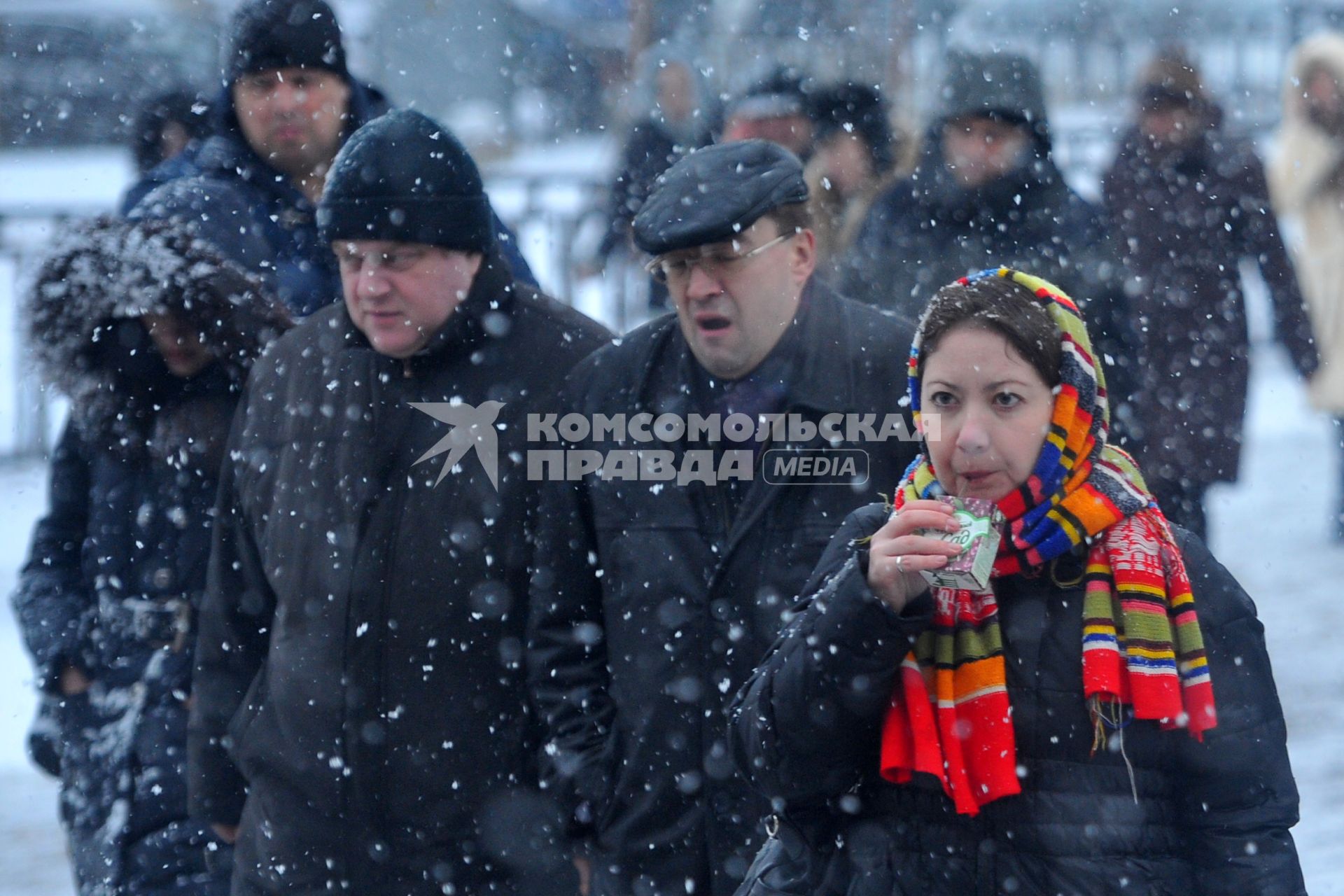 Снегопад в городе. На снимке: женщина пьет пакетированный сок.