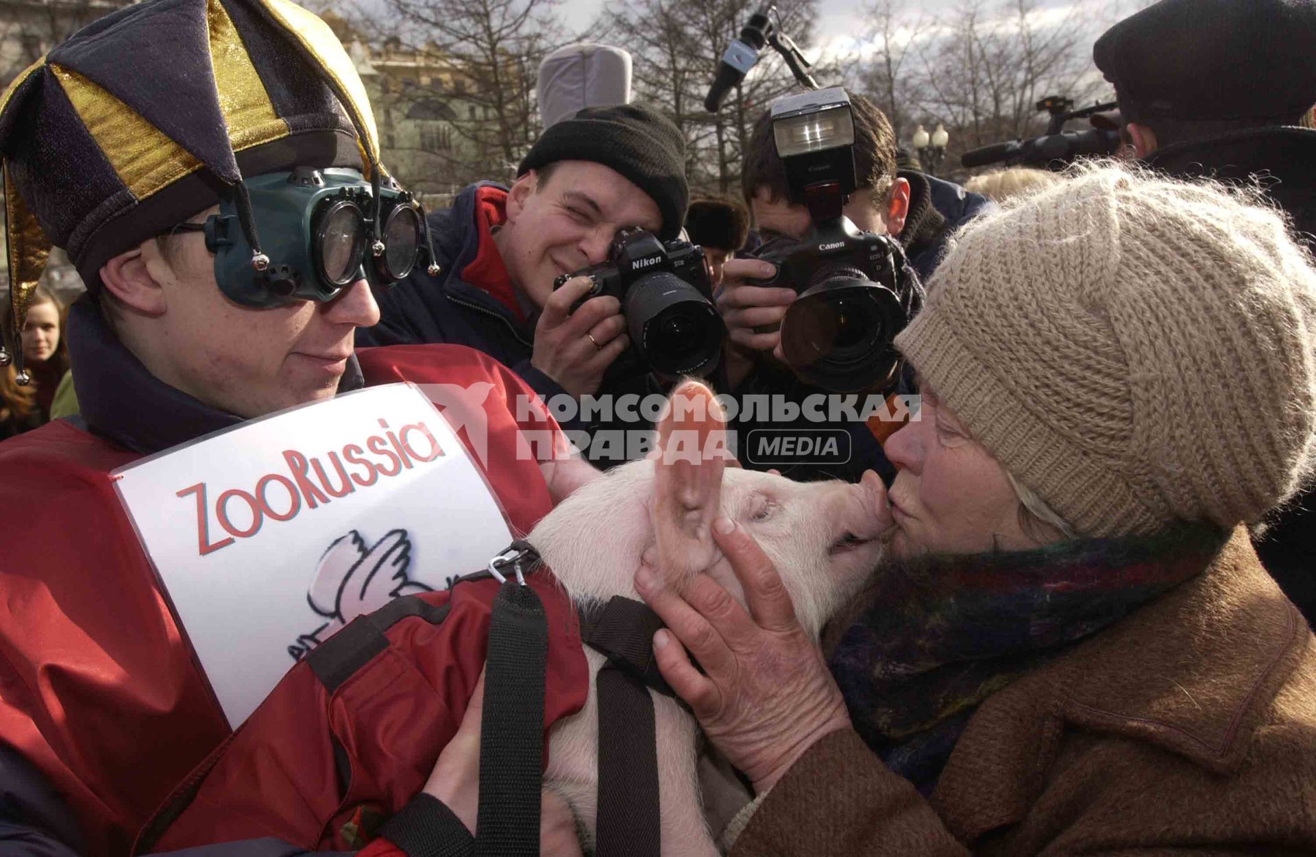 Женщина целует поросенка на поросячьих бегах в рамках международного Форума \"ЗОО РОССИЯ 2004\".