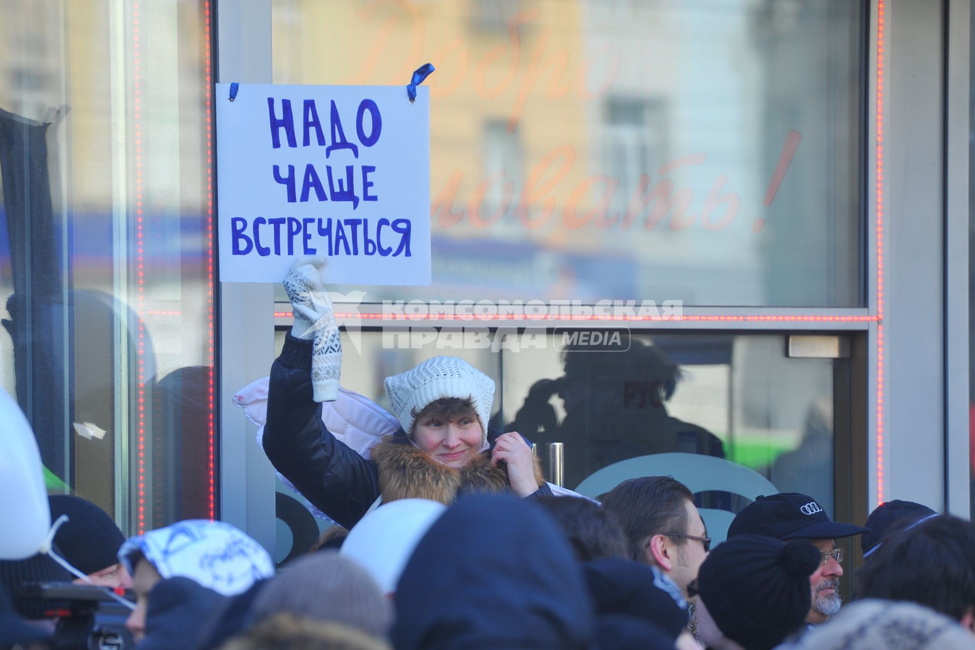 Новый Арбат. Женщина держит листок с надписью `Надо чаще встречаться`.