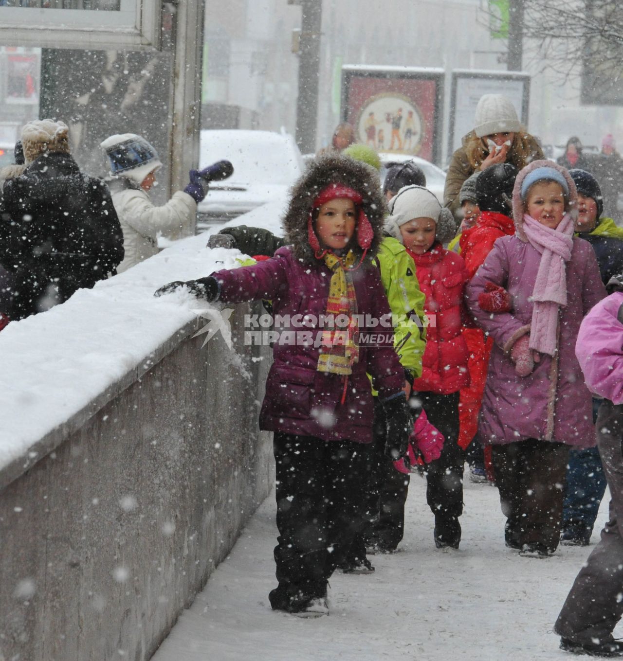 Снегопад в городе.  На снимке: подружки на зимней прогулке.