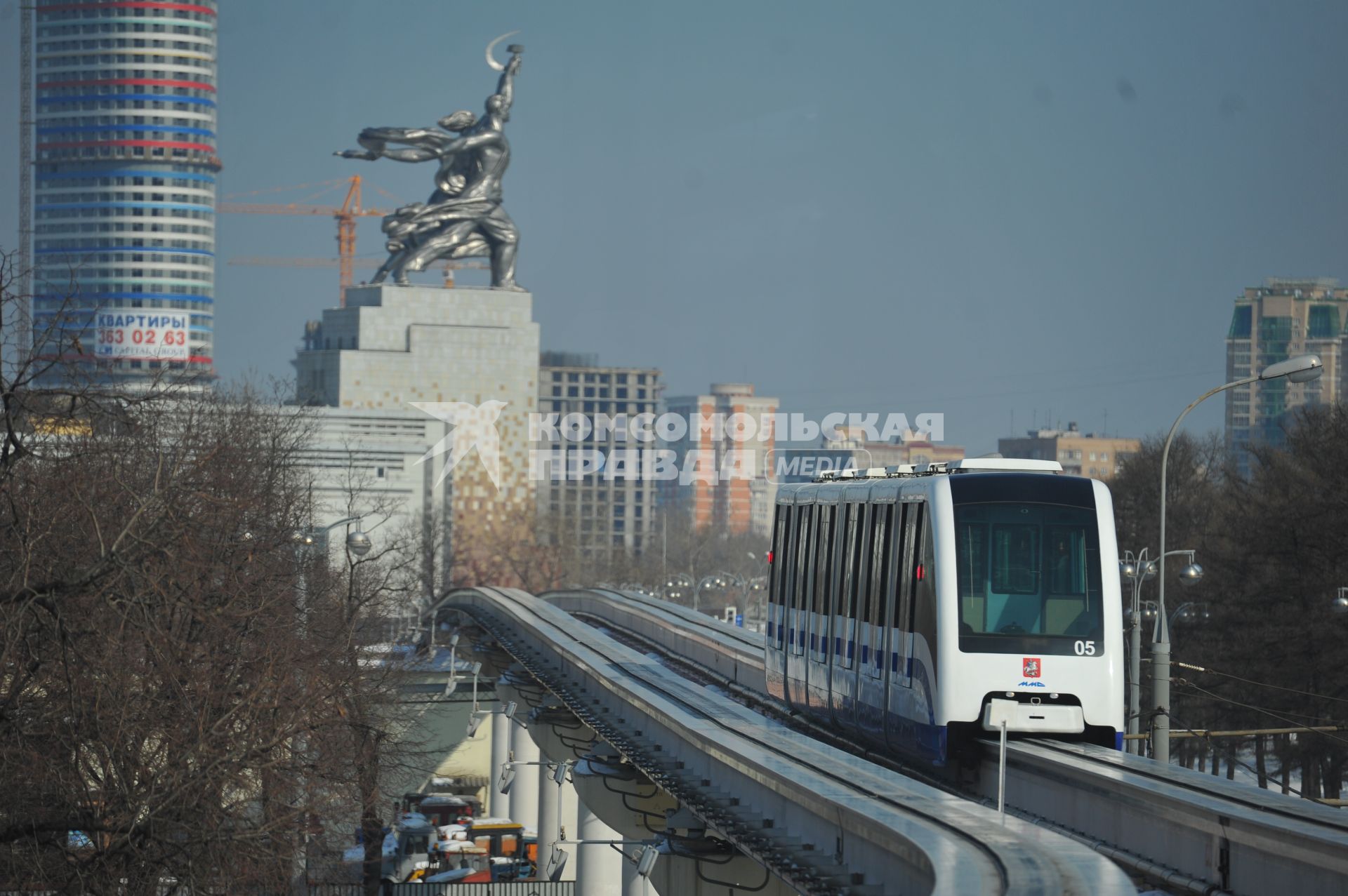 Московская монорельсовая транспортная система (ММТС). На снимке: монорельсовый поезд и памятник `Рабочий и колхозница`.