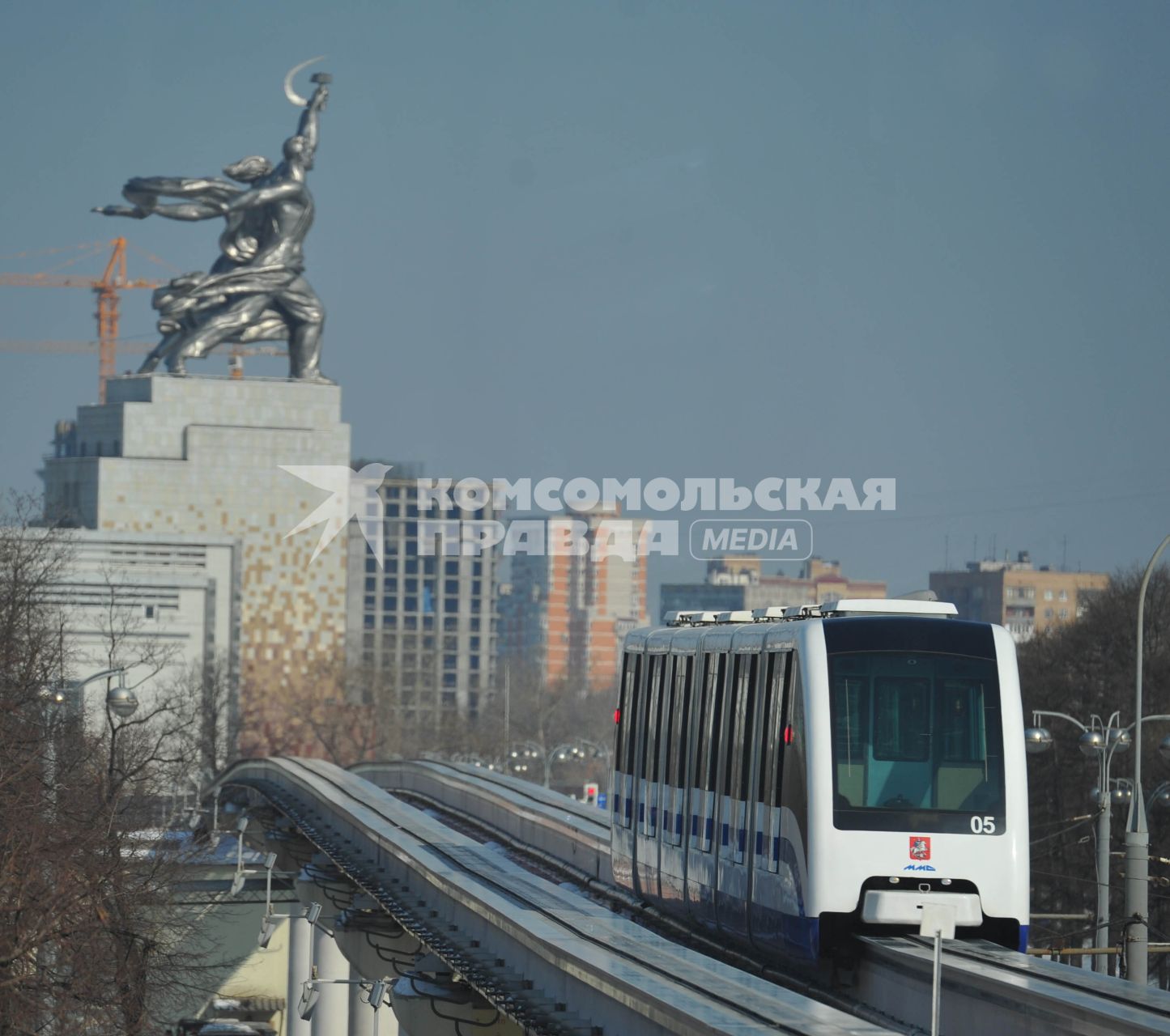 Московская монорельсовая транспортная система (ММТС). На снимке: монорельсовый поезд и памятник `Рабочий и колхозница`.