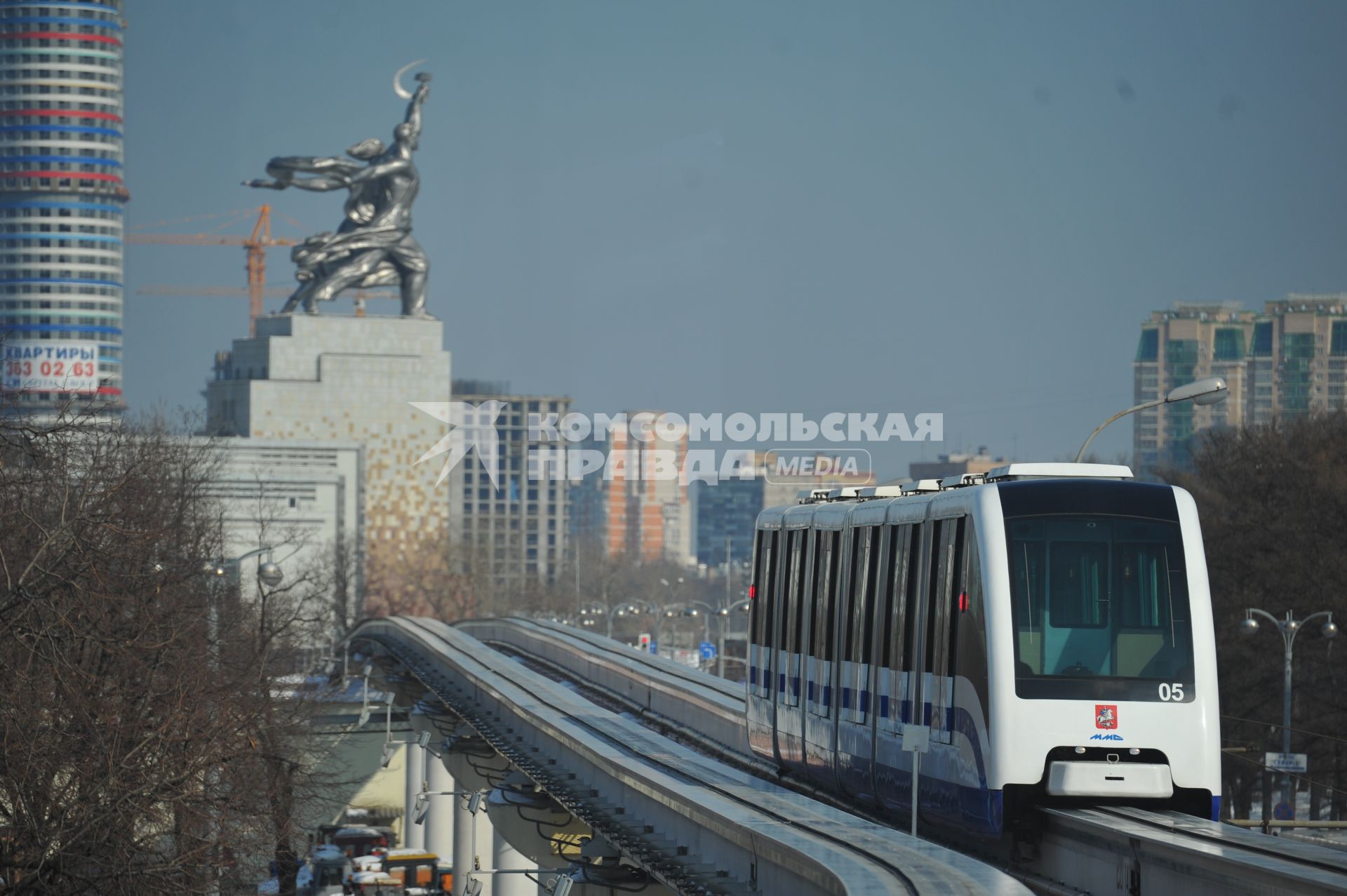 Московская монорельсовая транспортная система (ММТС). На снимке: монорельсовый поезд и памятник `Рабочий и колхозница`.