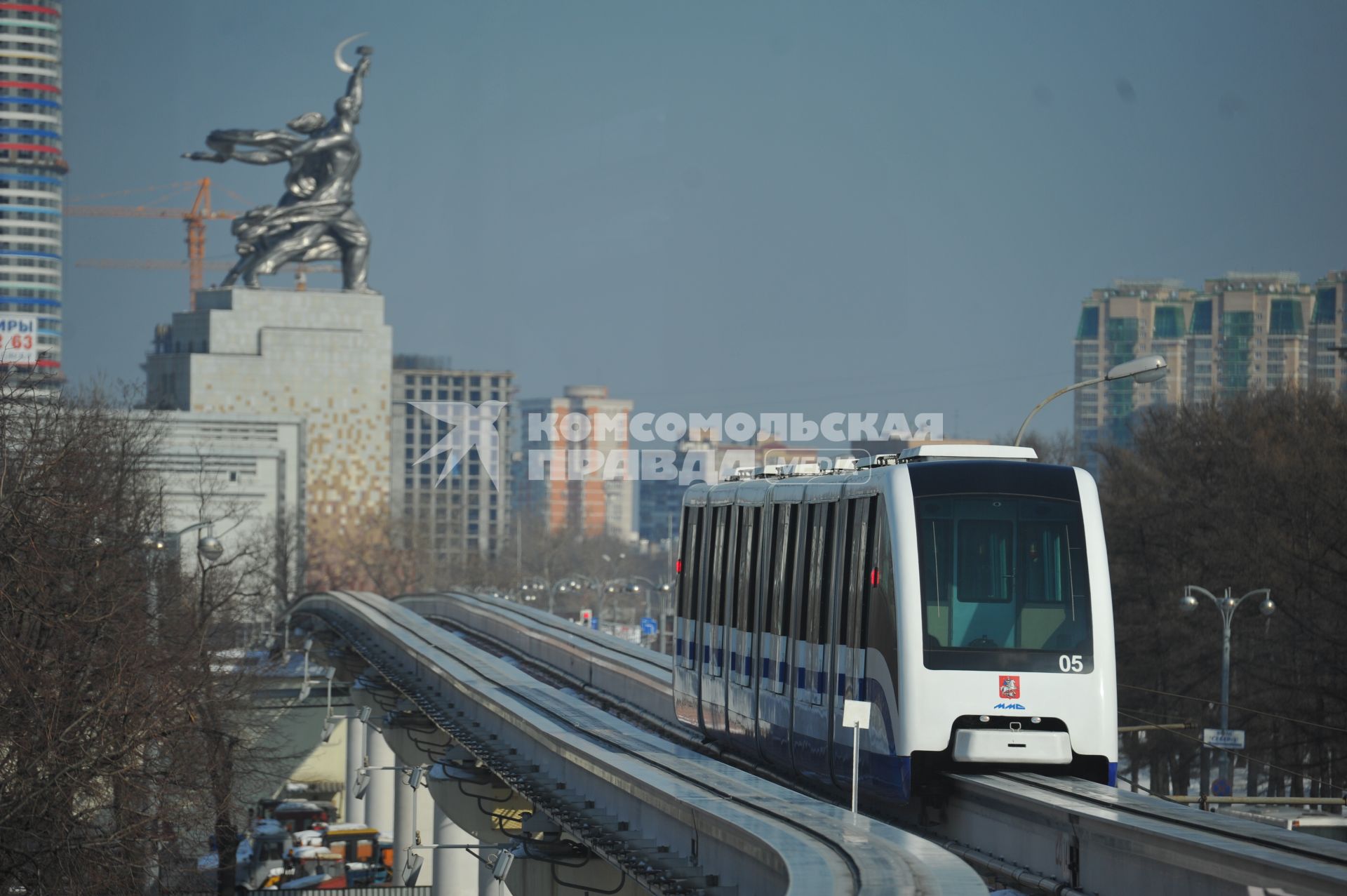 Московская монорельсовая транспортная система (ММТС). На снимке: монорельсовый поезд и памятник `Рабочий и колхозница`.