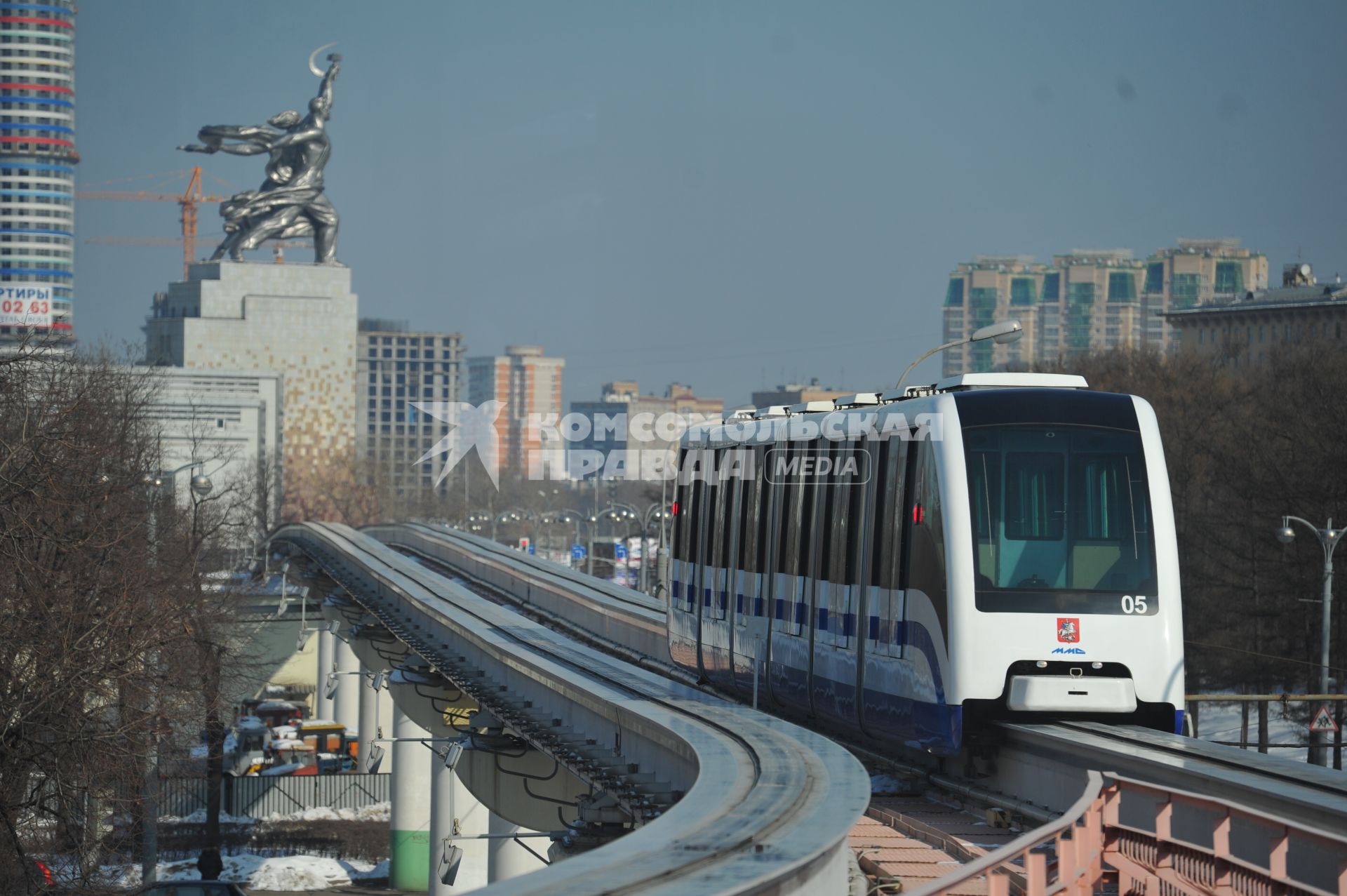 Московская монорельсовая транспортная система (ММТС). На снимке: монорельсовый поезд и памятник `Рабочий и колхозница`.