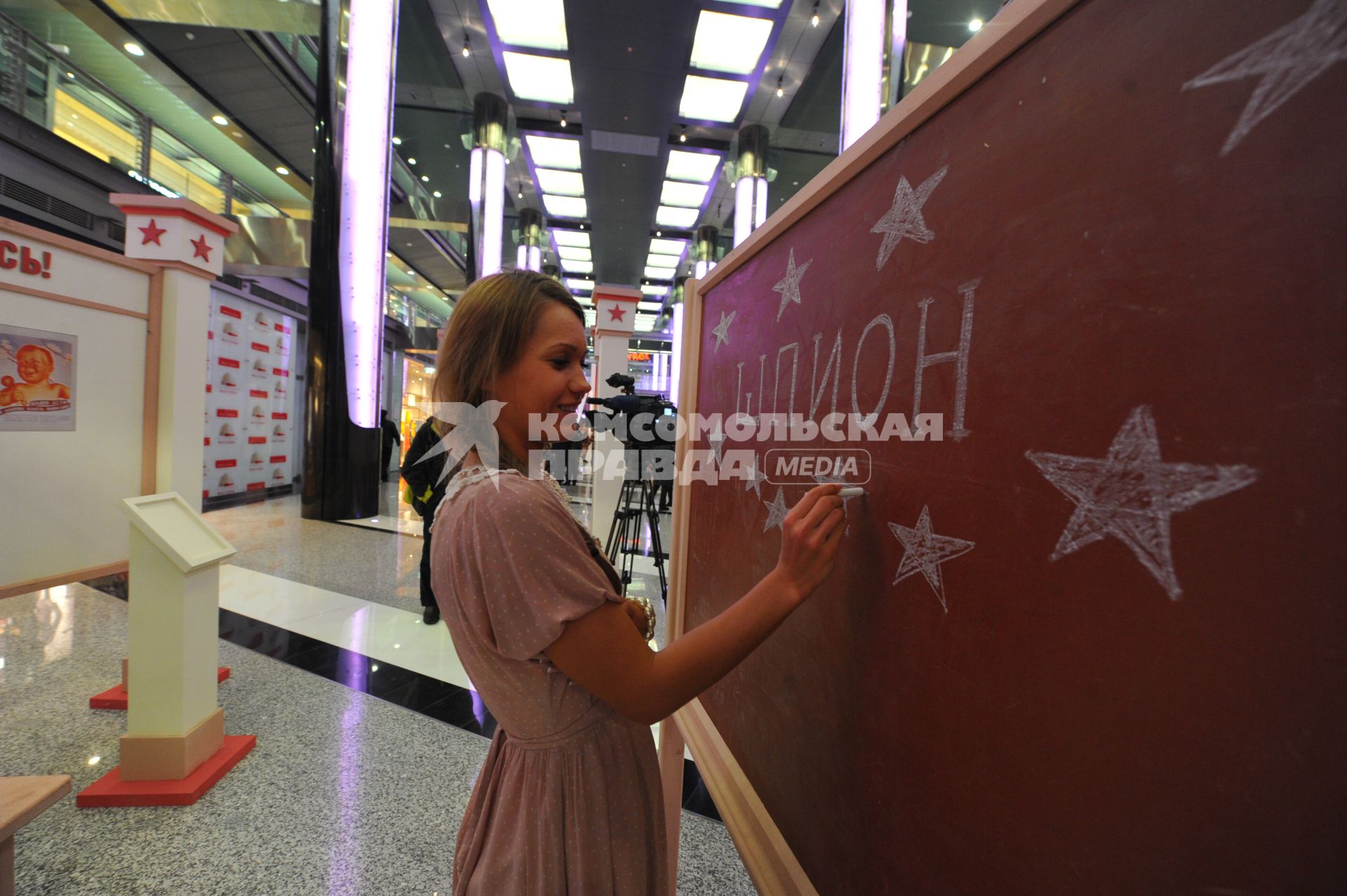 Галерея `Москва`. Выставка-аттракцион `Эпоха светлого завтра` по мотивам фильм `Шпион`, снятого по книге Бориса Акунина `Шпионский роман`. На снимке: девушка пишет мелом на доске слово `шпион`