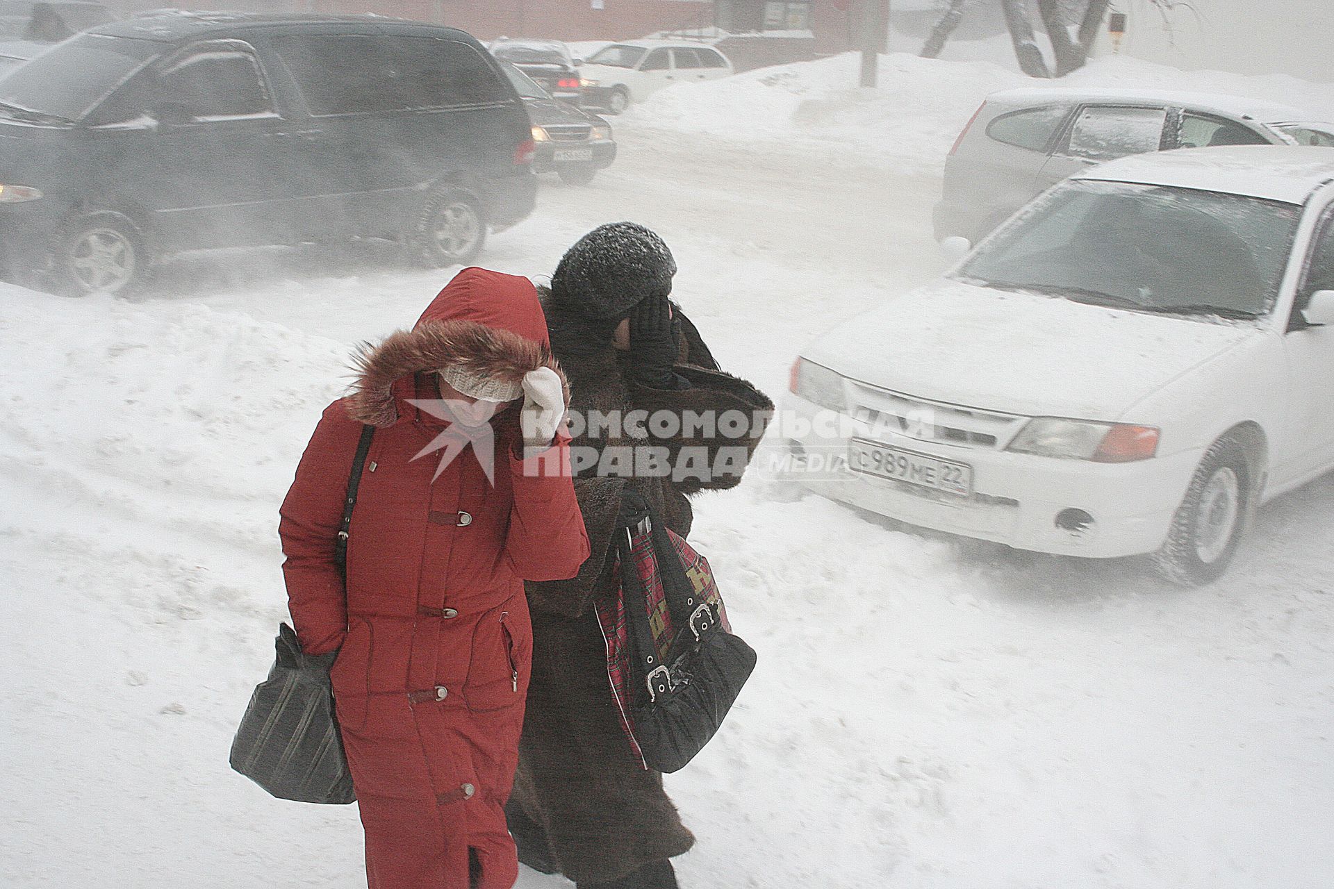 Метель, девушки идут по улице прикрывая лицо от снега.