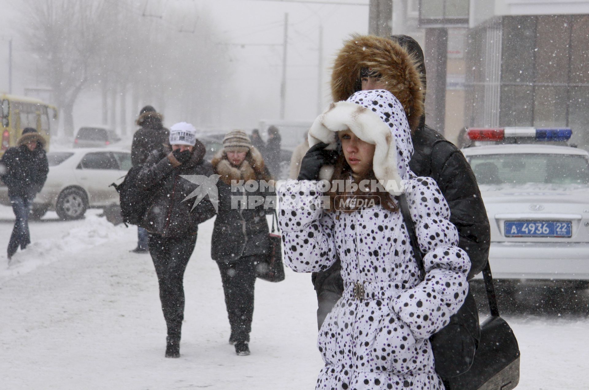 Зимняя непогода на улицах Барнаула. Люди прикрывают лица от сильного ветра со снегом.