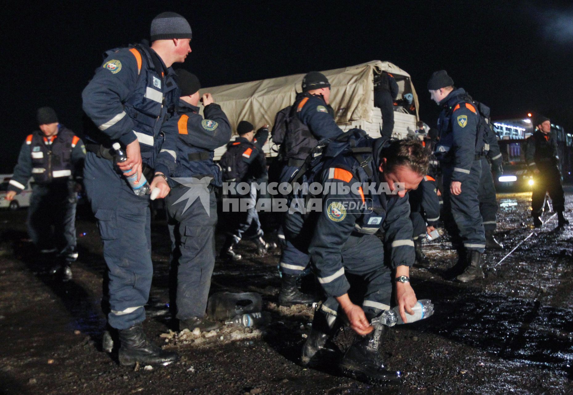 Спасатели отмывают обувь из бутылок с чистой питьевой водой.