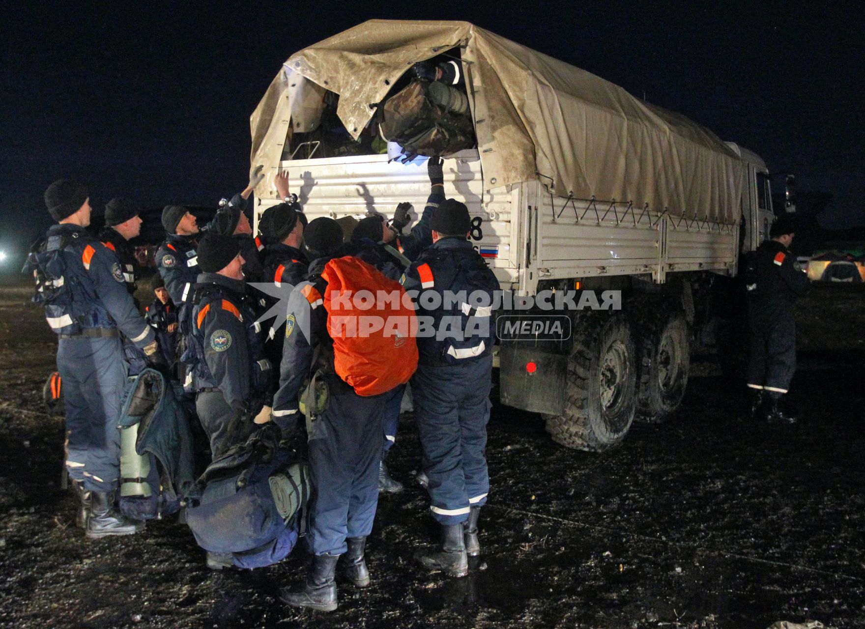 Спасатели загружают вещи в грузовик.