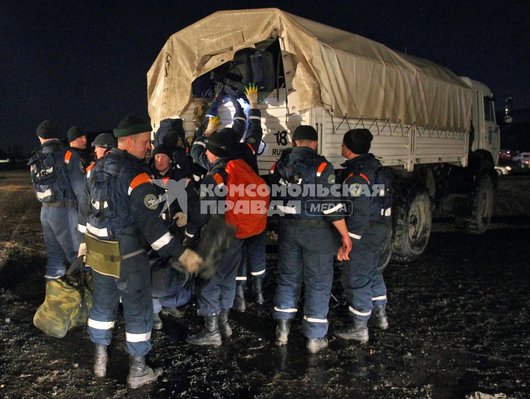 Спасатели загружают вещи в грузовик.