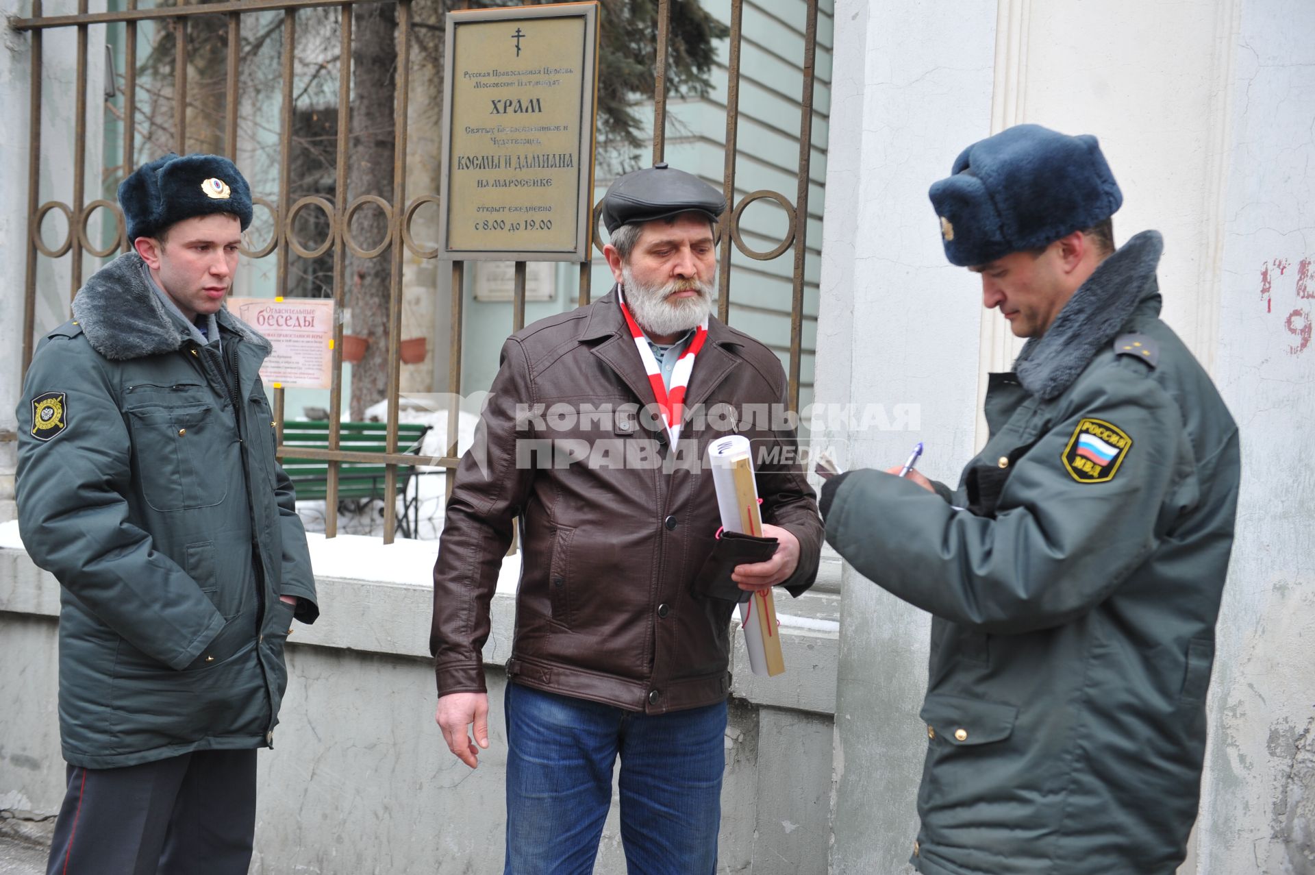 У посольства Белоруссии в Москве прошел пикет. На снимке: Полицейские проверяют документы у мужчины, который участвует в акции против смертной казни в Белоруссии. Храм Косьмы и Дамиана на Маросейке (на заднем плане).