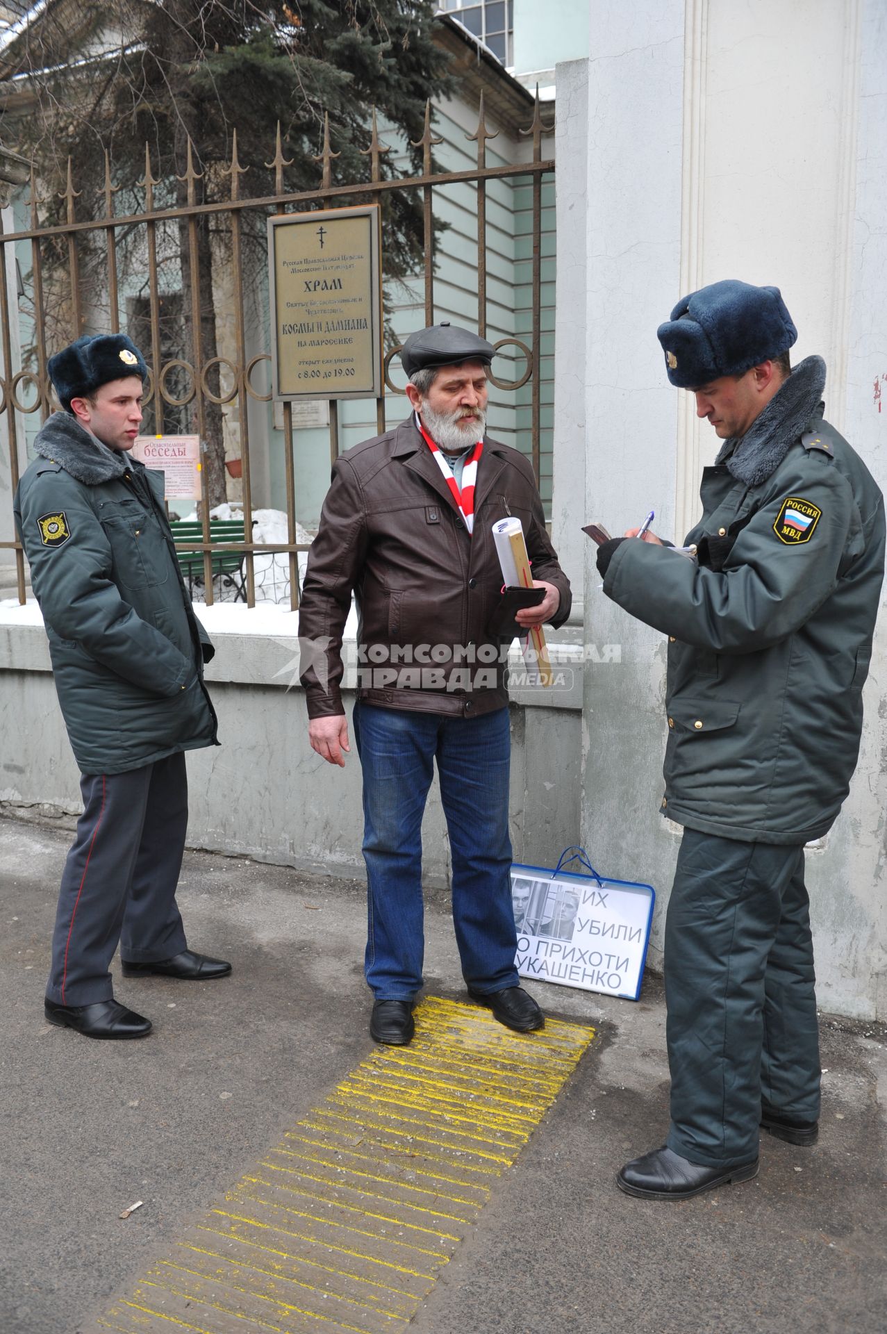 У посольства Белоруссии в Москве прошел пикет. На снимке: Полицейские проверяют документы у мужчины, который участвует в акции против смертной казни в Белоруссии. Храм Косьмы и Дамиана на Маросейке (на заднем плане).