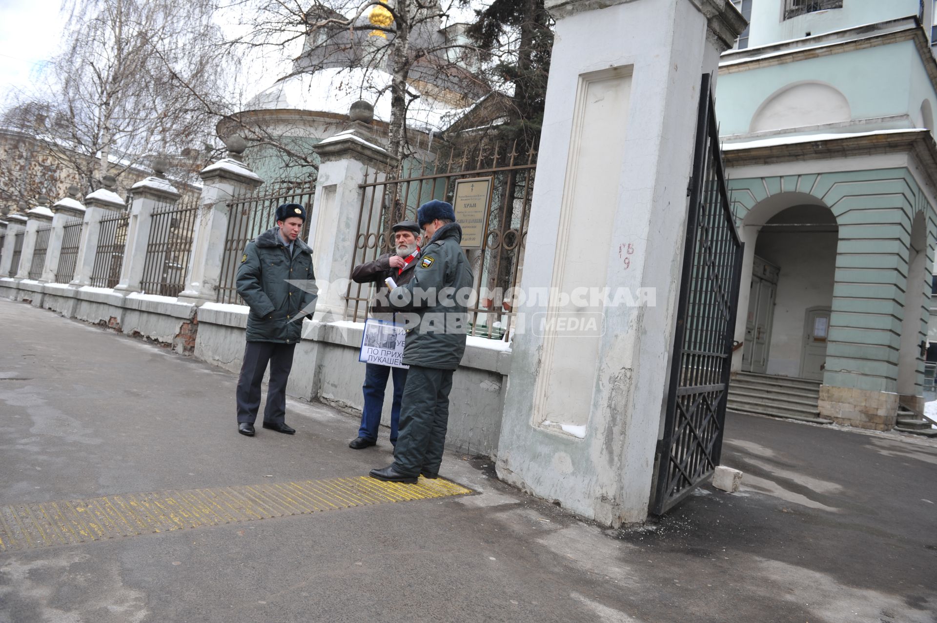 У посольства Белоруссии в Москве прошел пикет. На снимке: Полицейские проверяют документы у мужчины, который участвует в акции против смертной казни в Белоруссии. Храм Косьмы и Дамиана на Маросейке (на заднем плане).