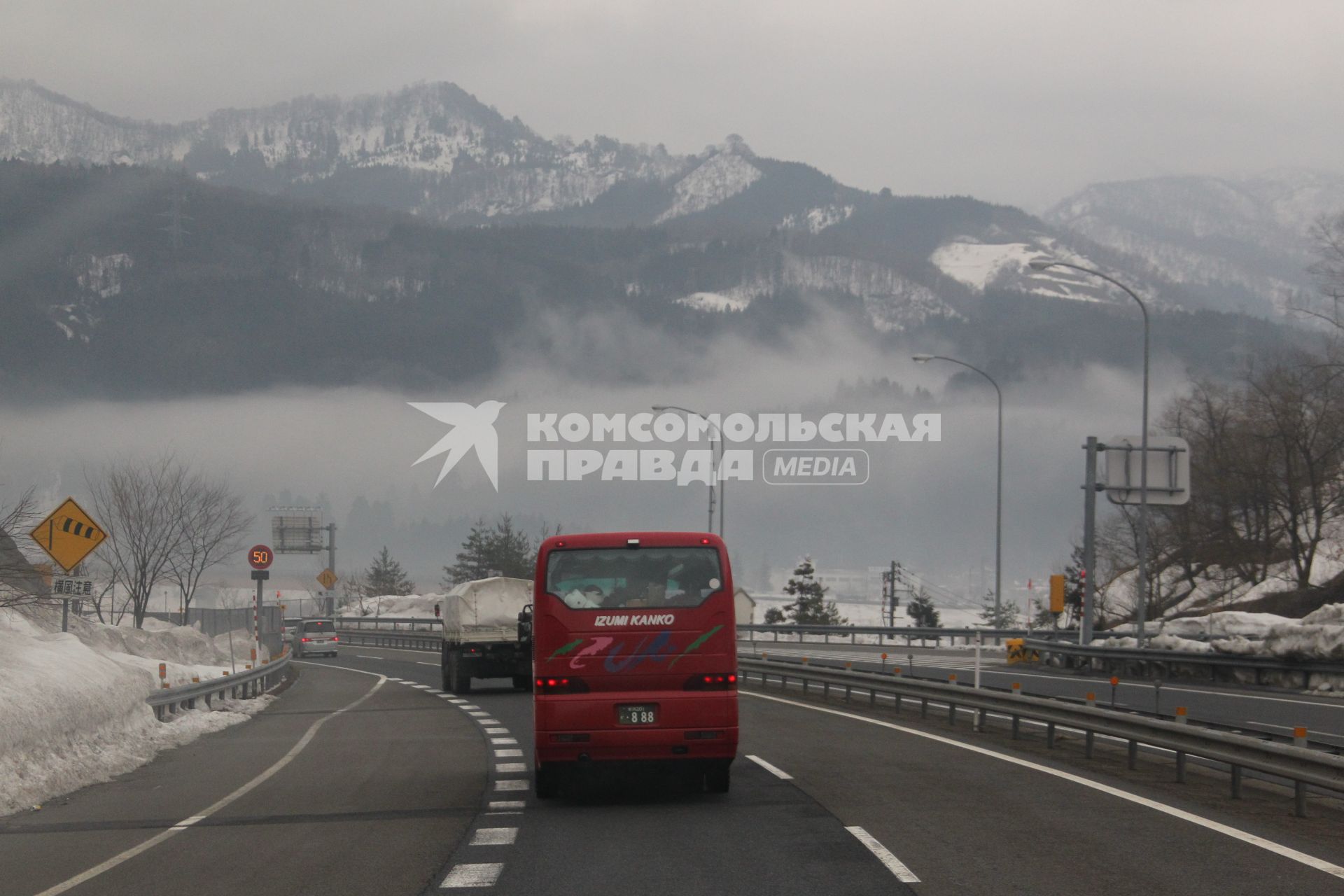 Виды Японии. Автомобили движутся по дороге на фоне гор.