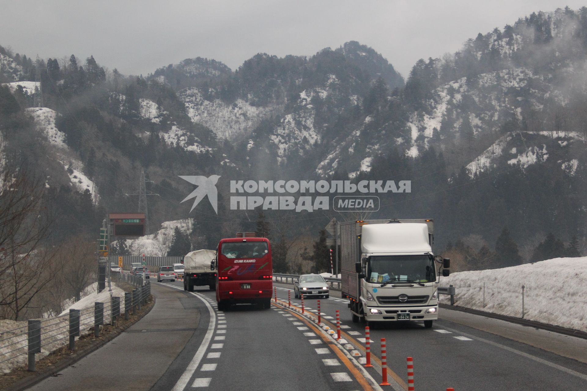 Виды Японии. Автомобили движутся по дороге на фоне гор.