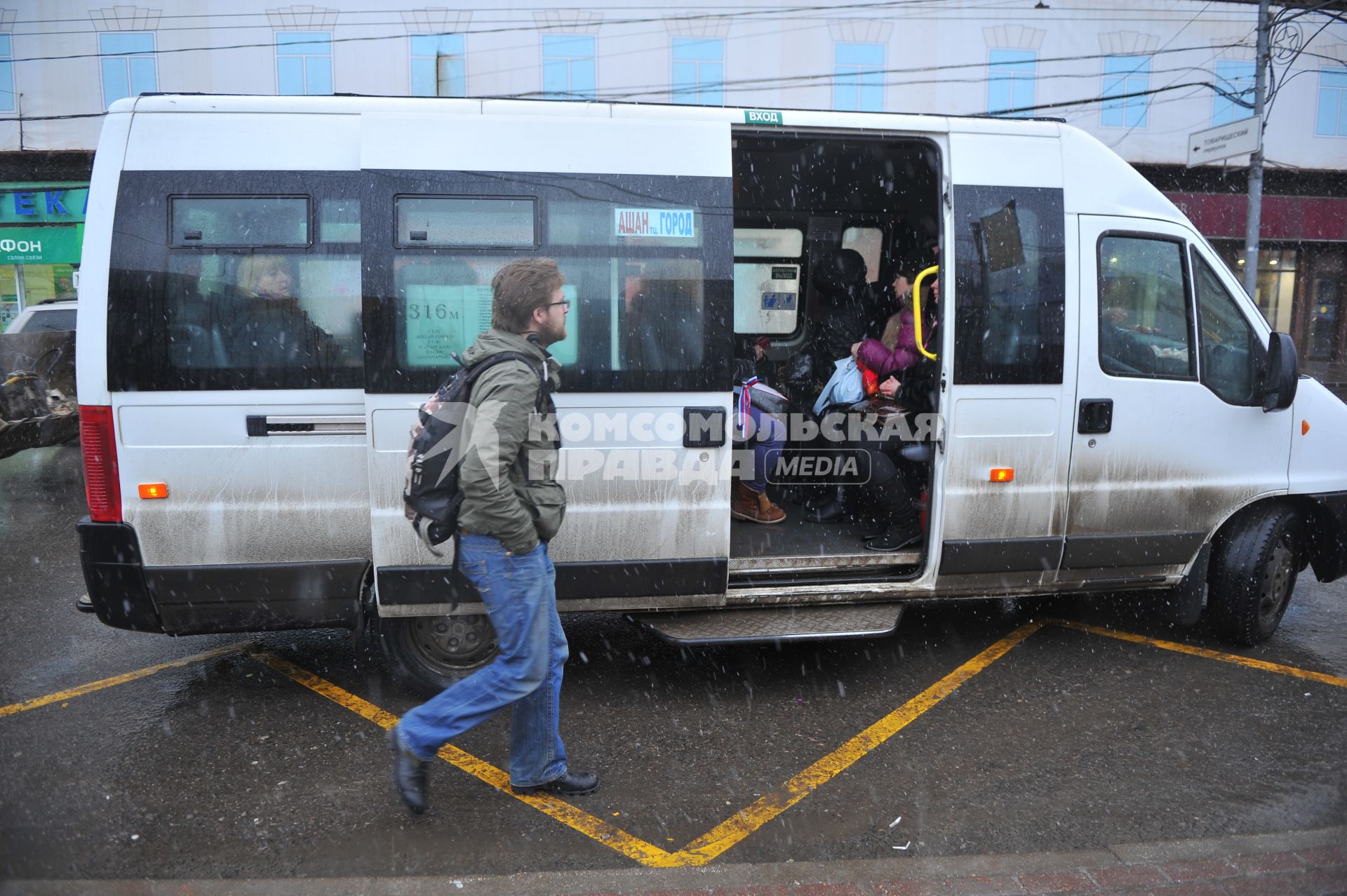 Мужчина подходит к маршрутному автобусу.