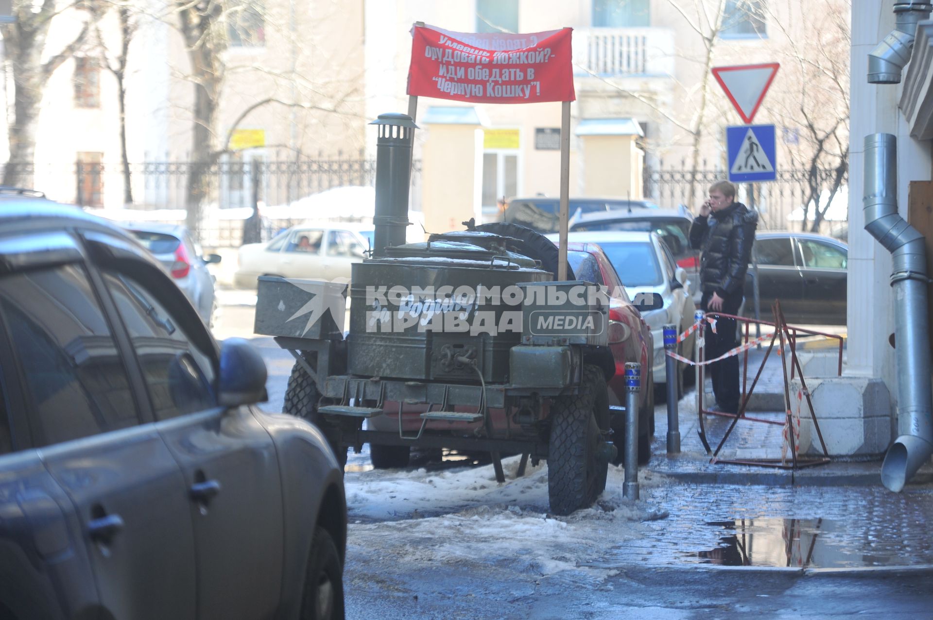 Вдоль дороги припаркован военный прицеп с надписью ЗА РОДИНУ.