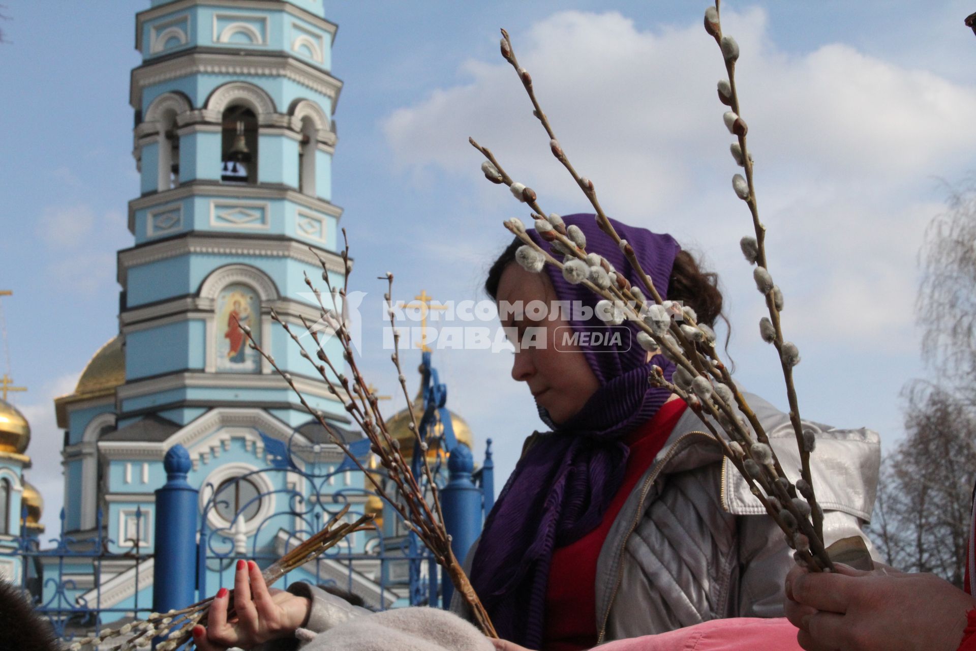 Девушка у храма с ветками вербы.